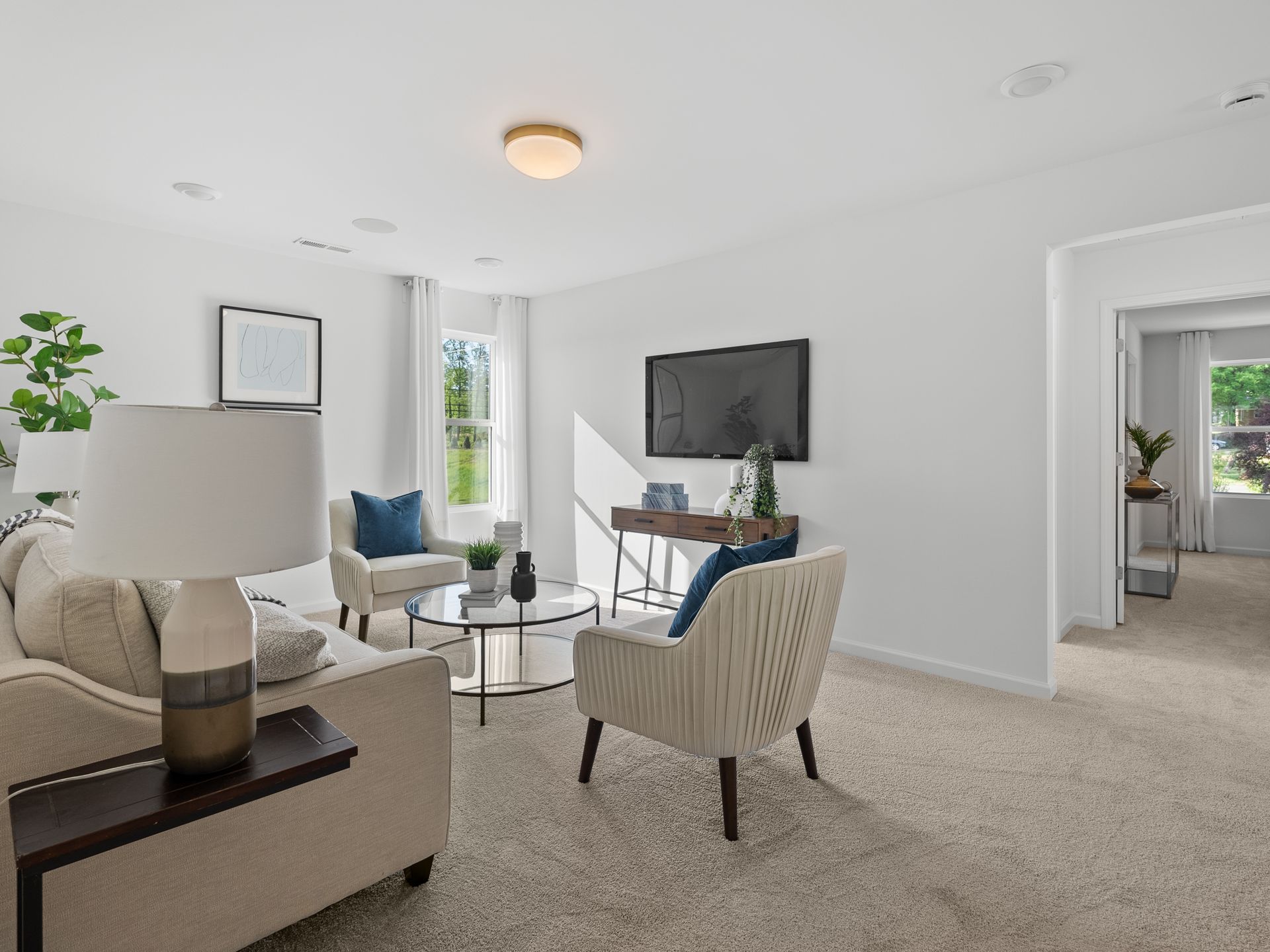 A living room with a couch , chairs , table and television.
