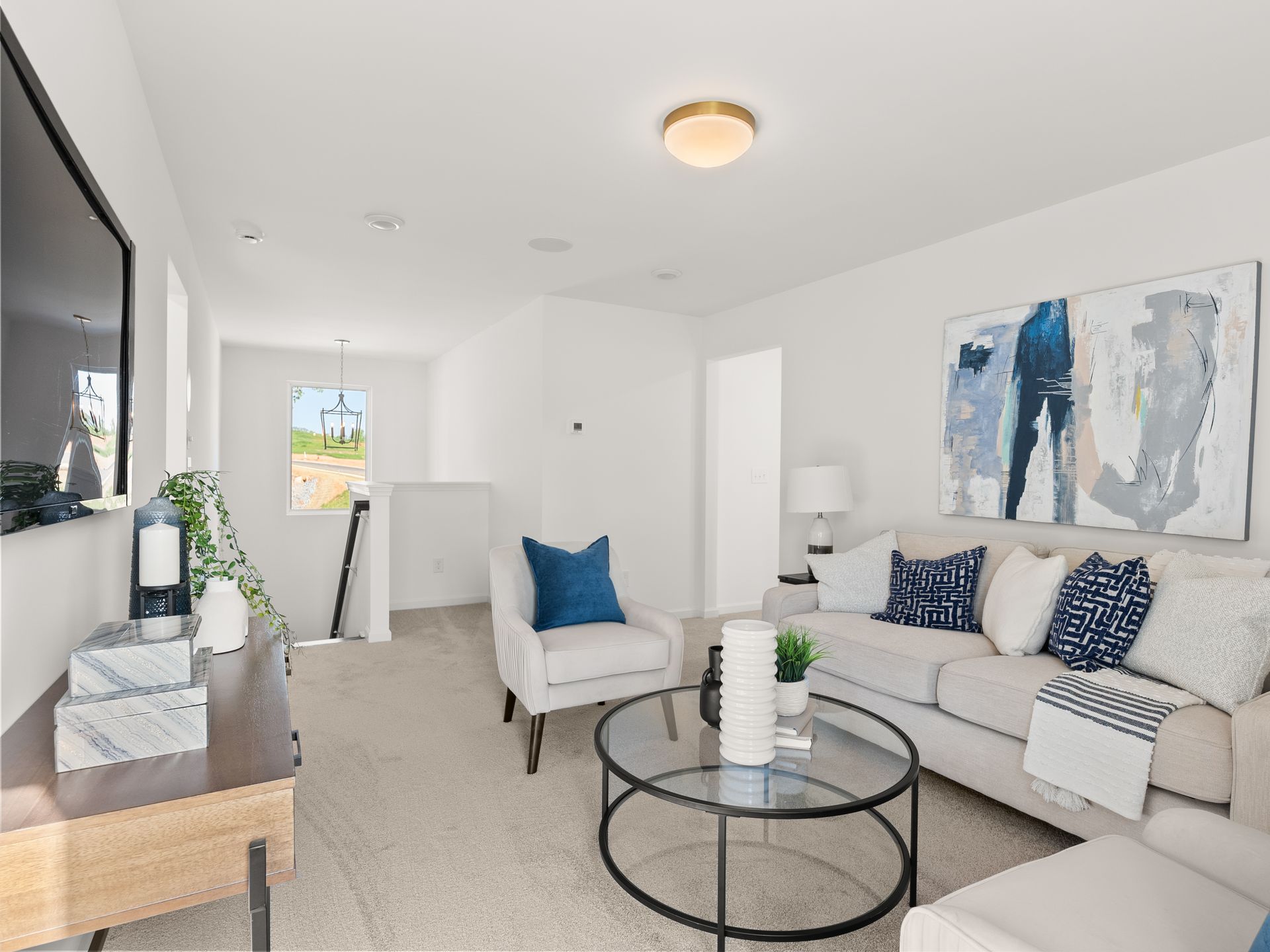 A living room with a couch , chair , coffee table and television.