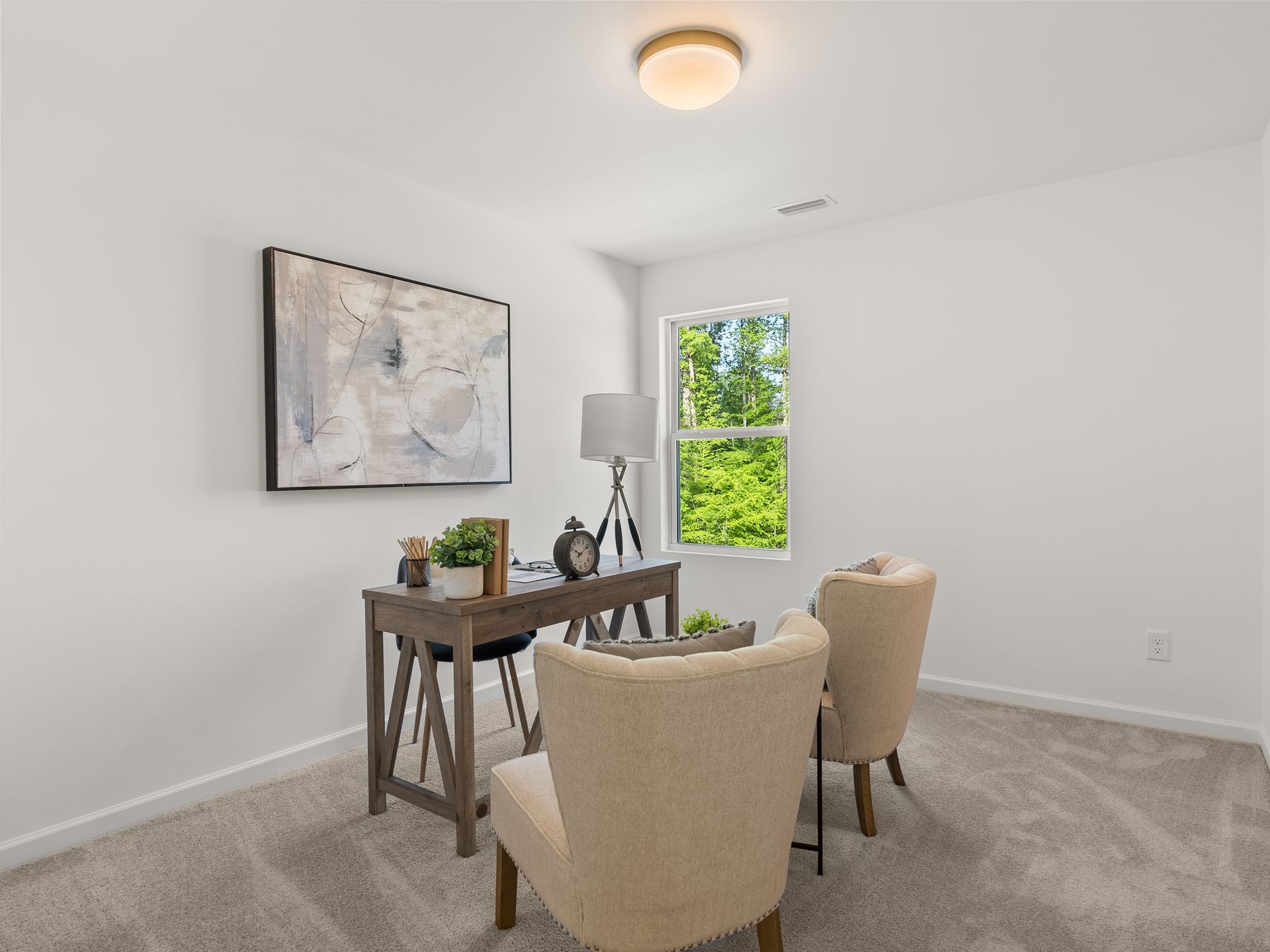 A room with two chairs , a desk and a window.