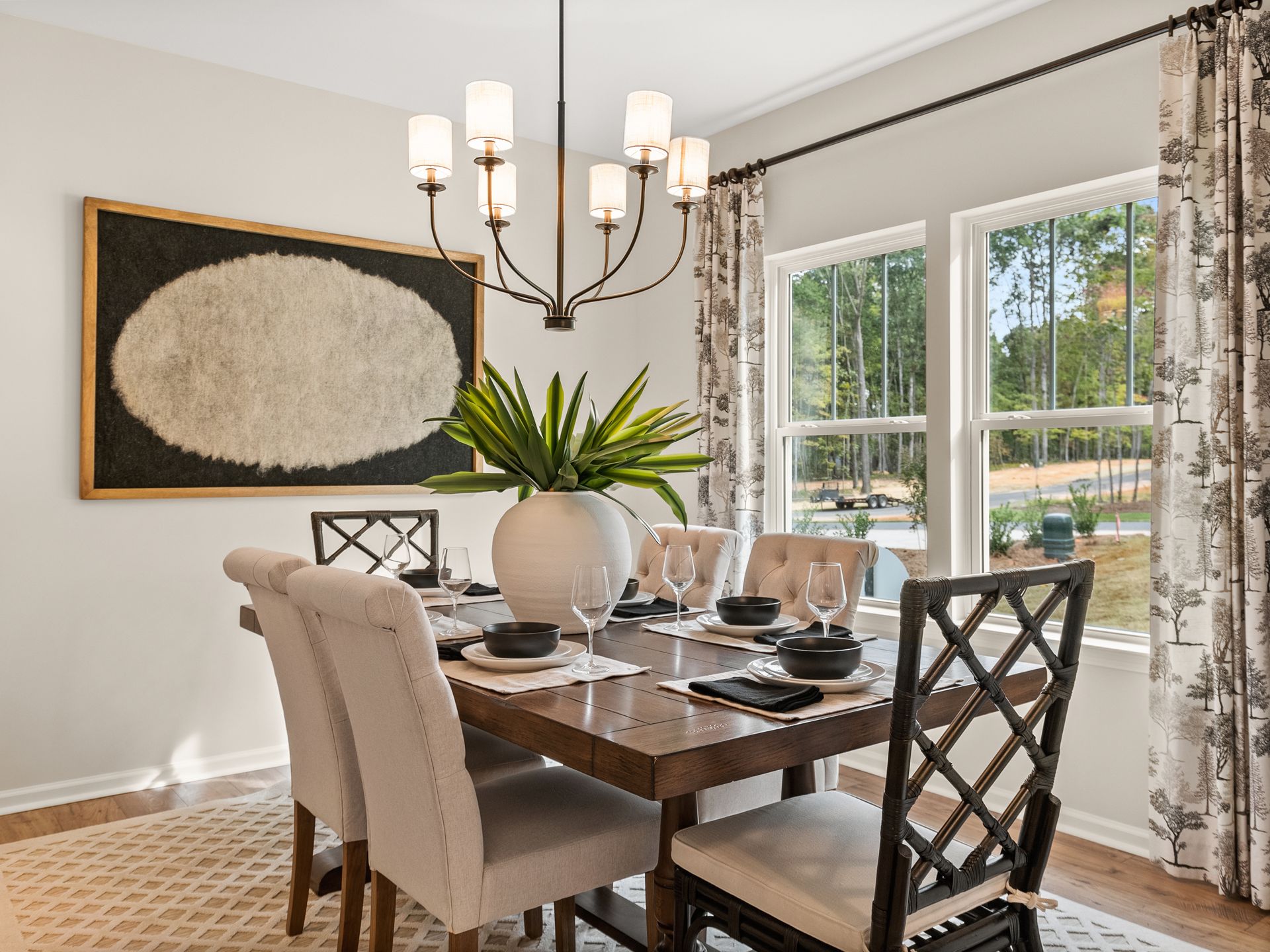A dining room with a table and chairs and a chandelier.