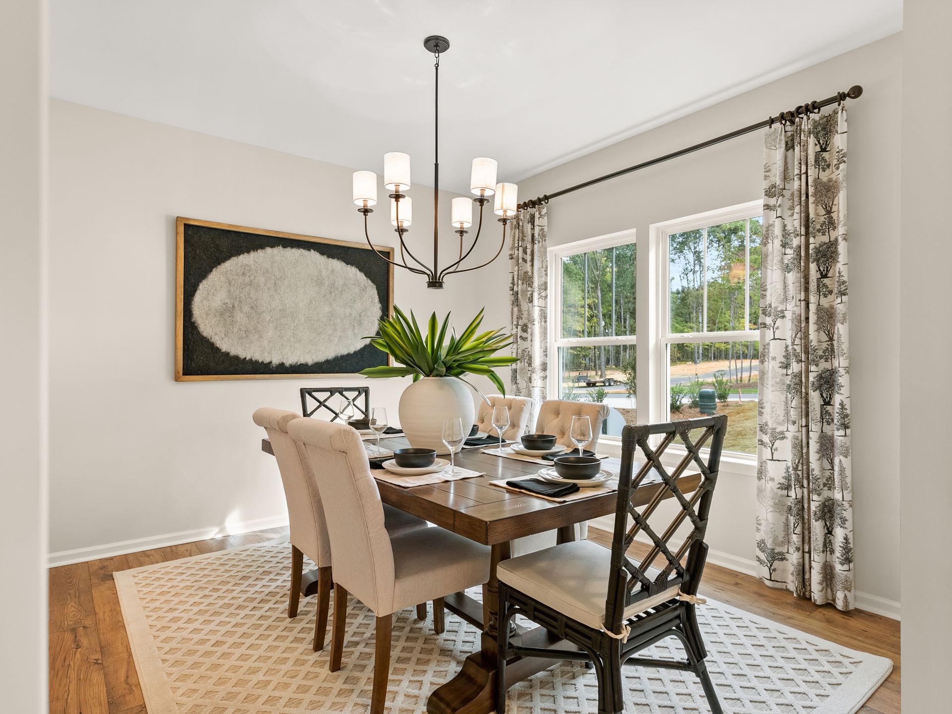 A dining room with a table and chairs and a chandelier.
