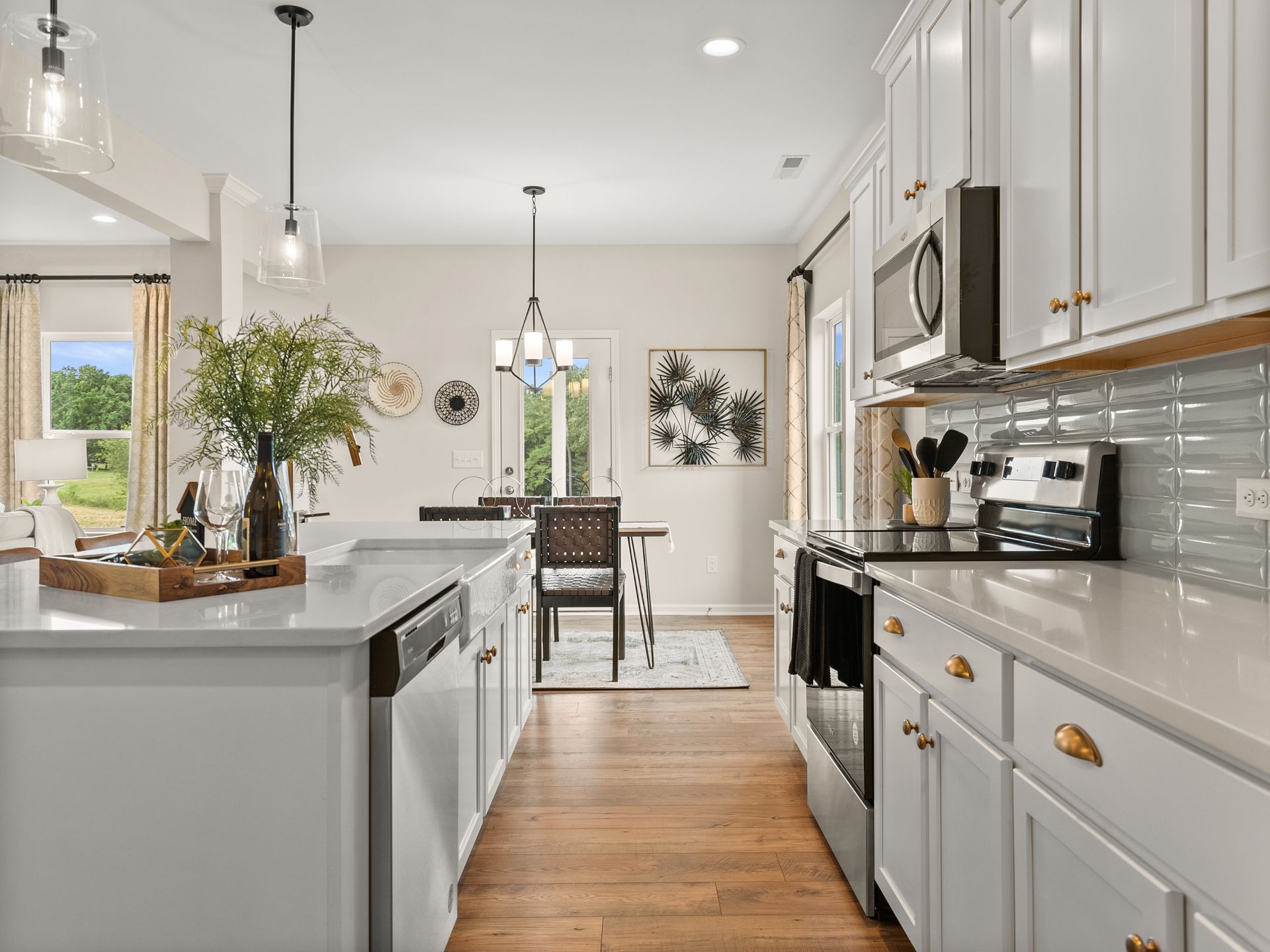 A kitchen with white cabinets , stainless steel appliances , and hardwood floors.