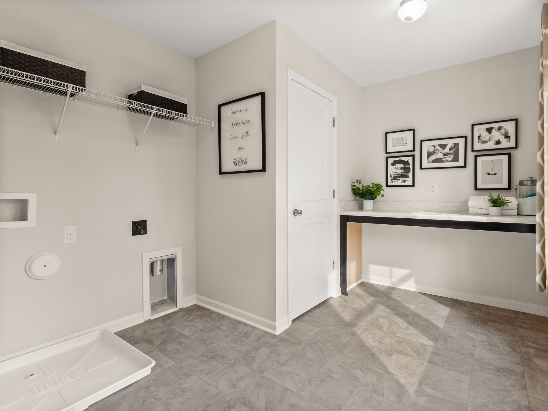A laundry room with a washer and dryer and a desk.