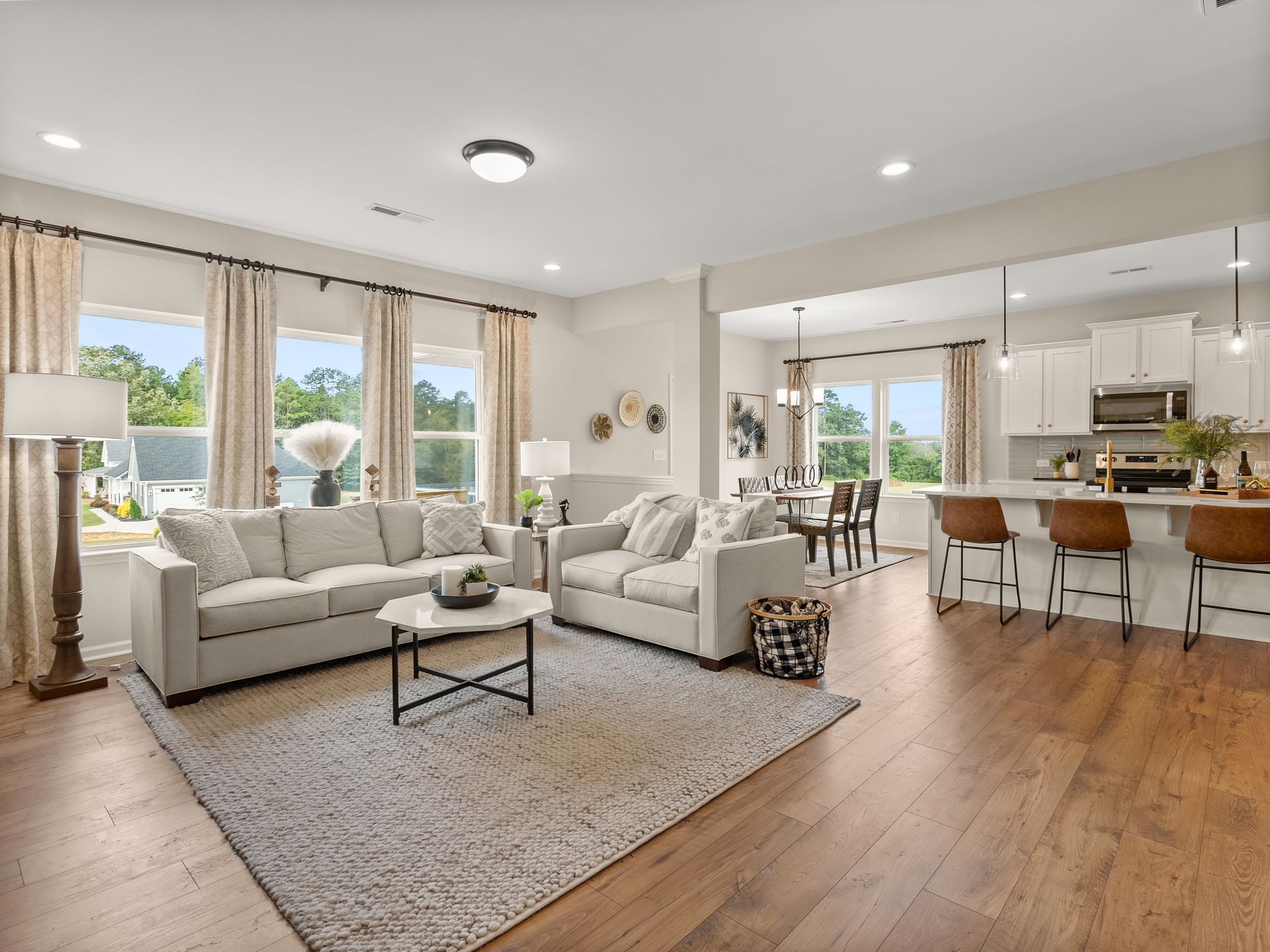 A living room with two couches , a coffee table , and a kitchen.