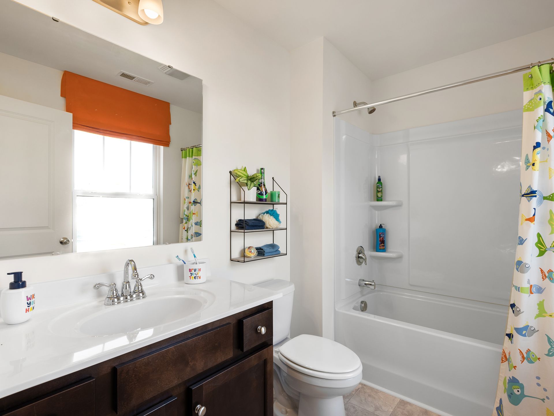 A bathroom with a sink , toilet , tub and mirror.