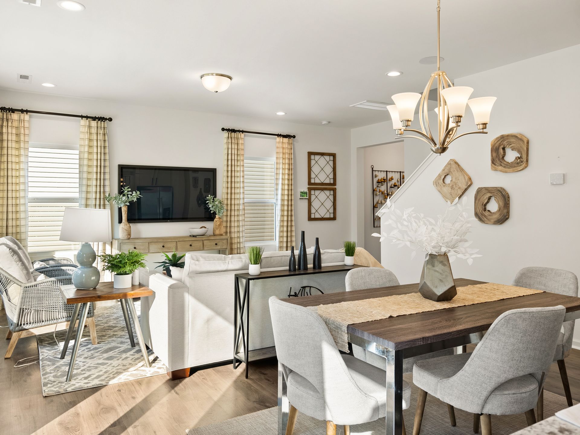 A living room with a dining table and chairs and a flat screen tv.