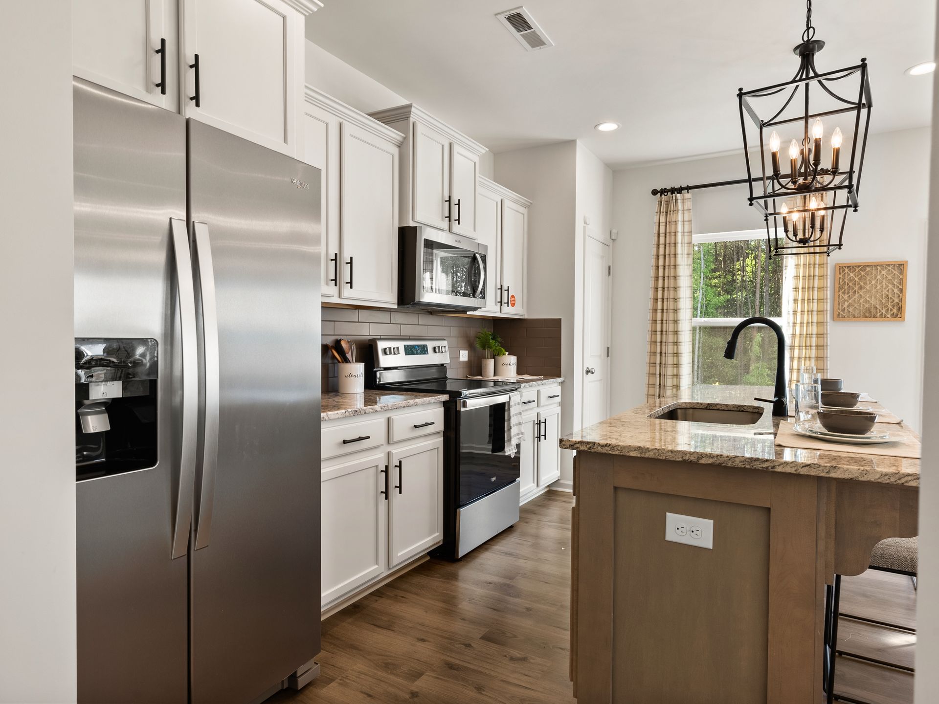 A kitchen with stainless steel appliances and white cabinets.