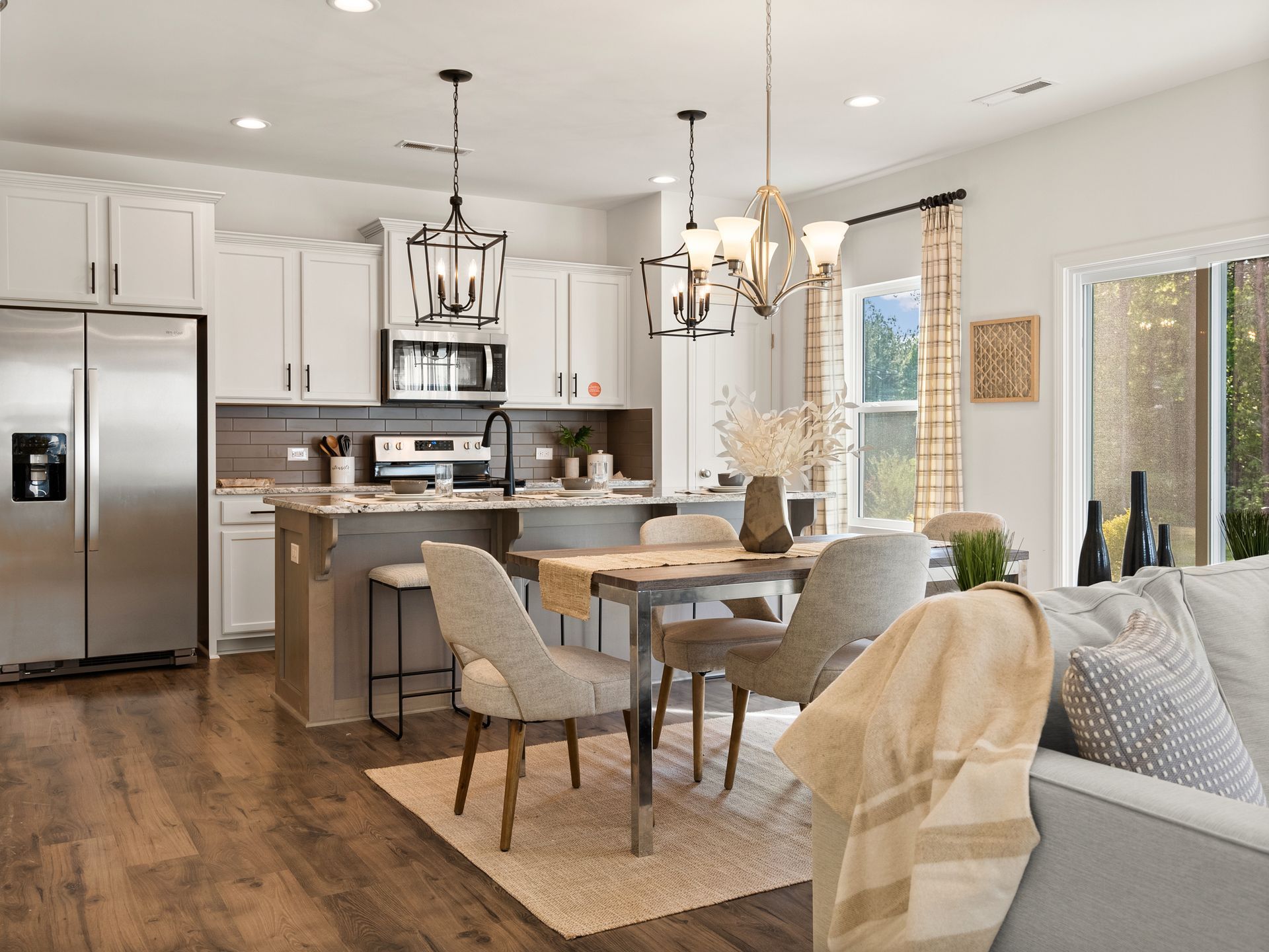 A living room , dining room , and kitchen in a model home.