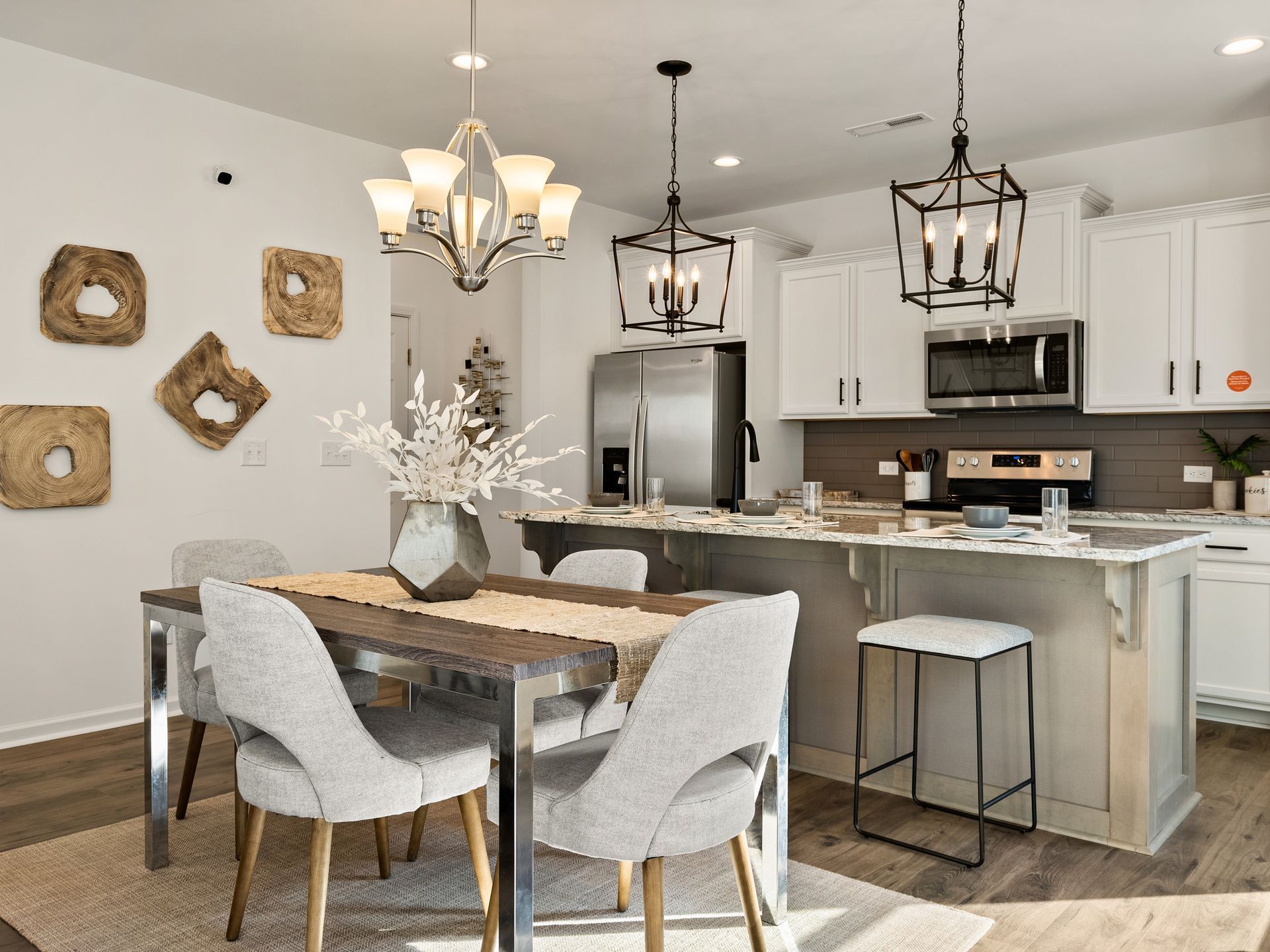 A dining room with a table and chairs in front of a kitchen.