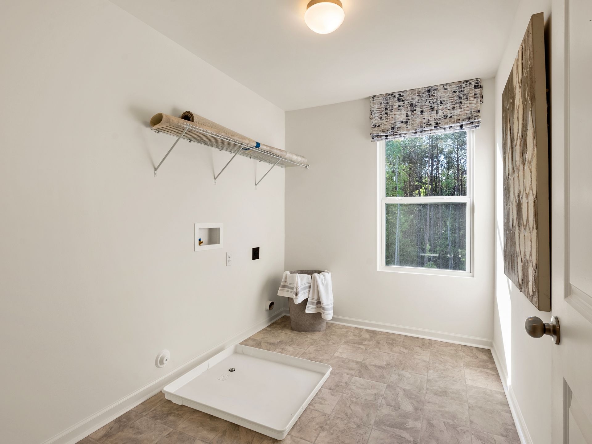 A laundry room with a washer and dryer and a window.