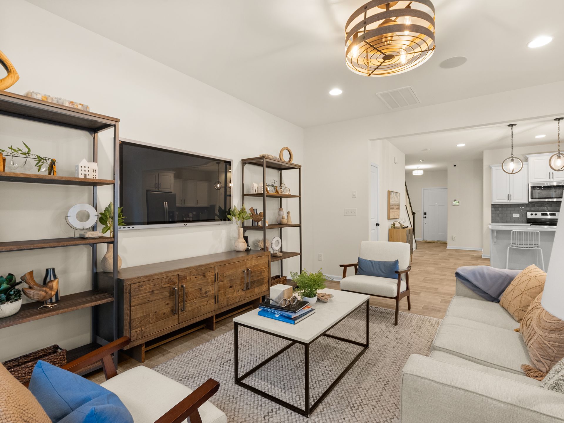 A living room with a couch , chairs , a coffee table and a flat screen tv.