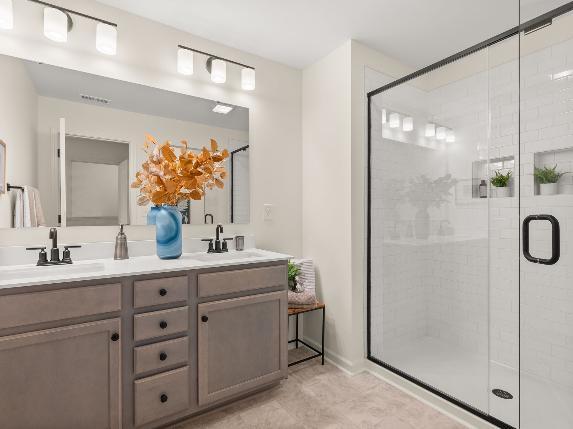 A bathroom with two sinks and a walk in shower.