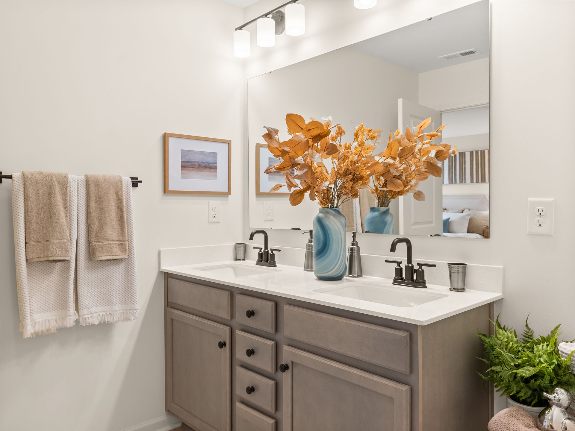 A bathroom with two sinks and a large mirror.