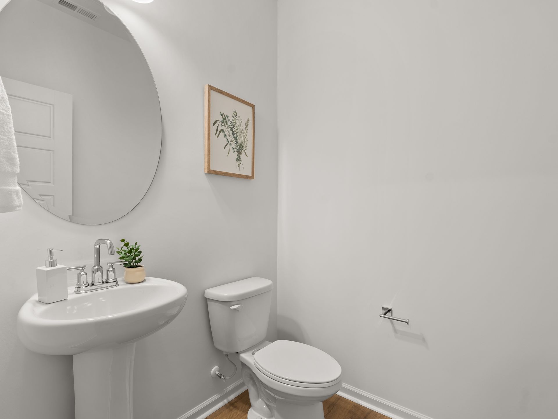 A bathroom with a sink , toilet and mirror.