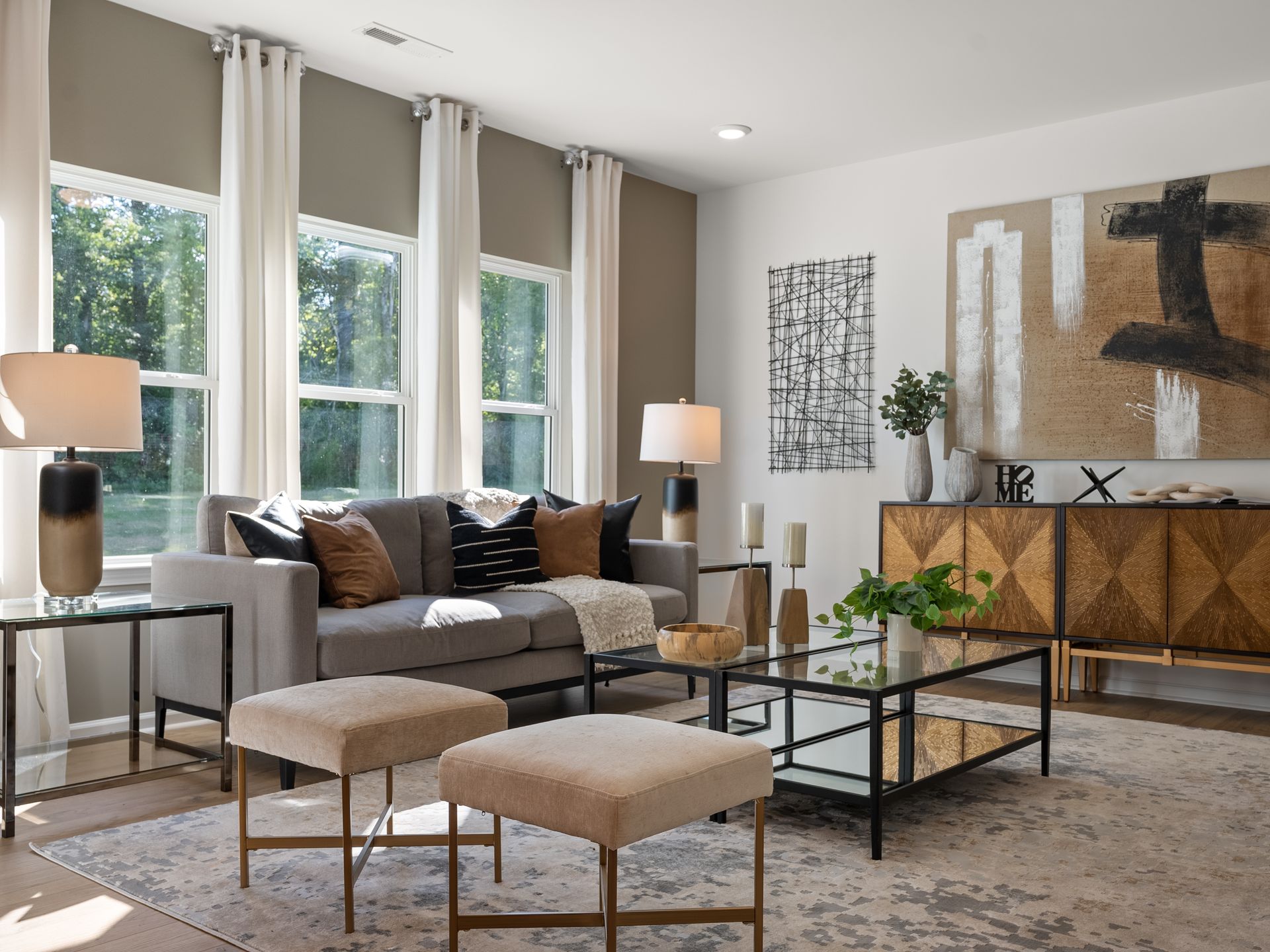 A living room with a couch , coffee table , ottomans and lamps.