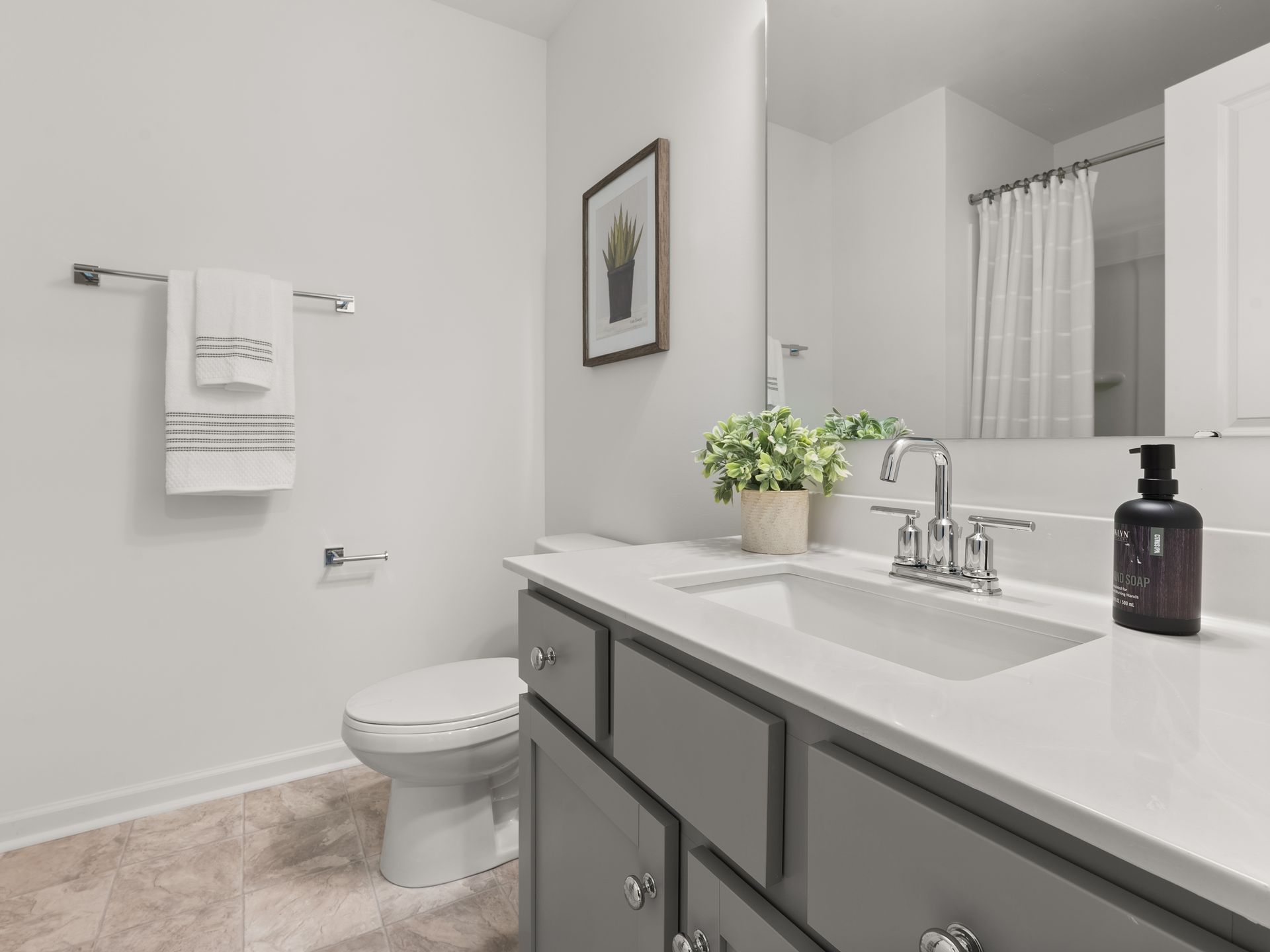A bathroom with a toilet , sink , and mirror.