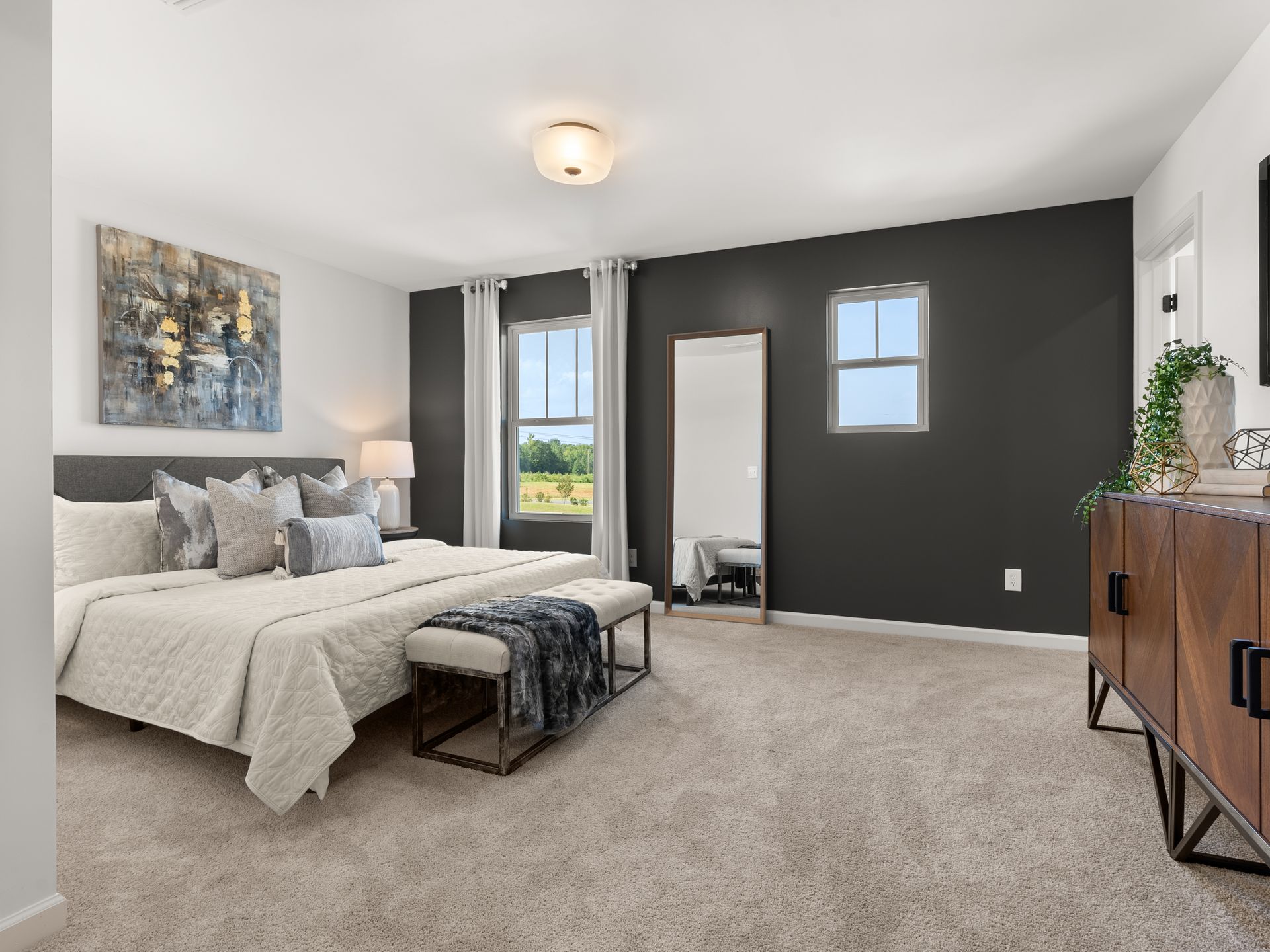 A bedroom with two beds , a dresser and a mirror.