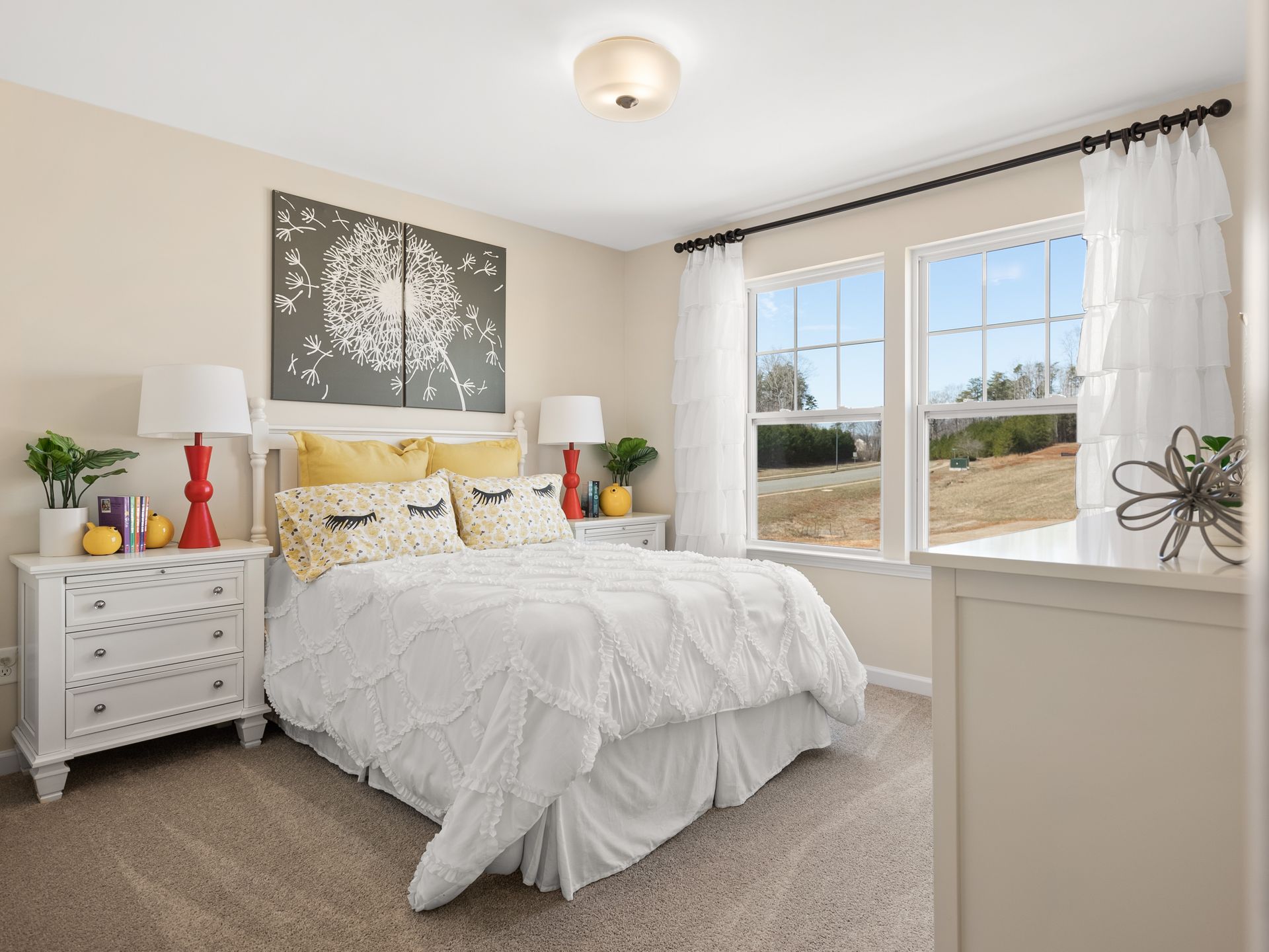 A bedroom with a bed , nightstands , lamps and two windows.