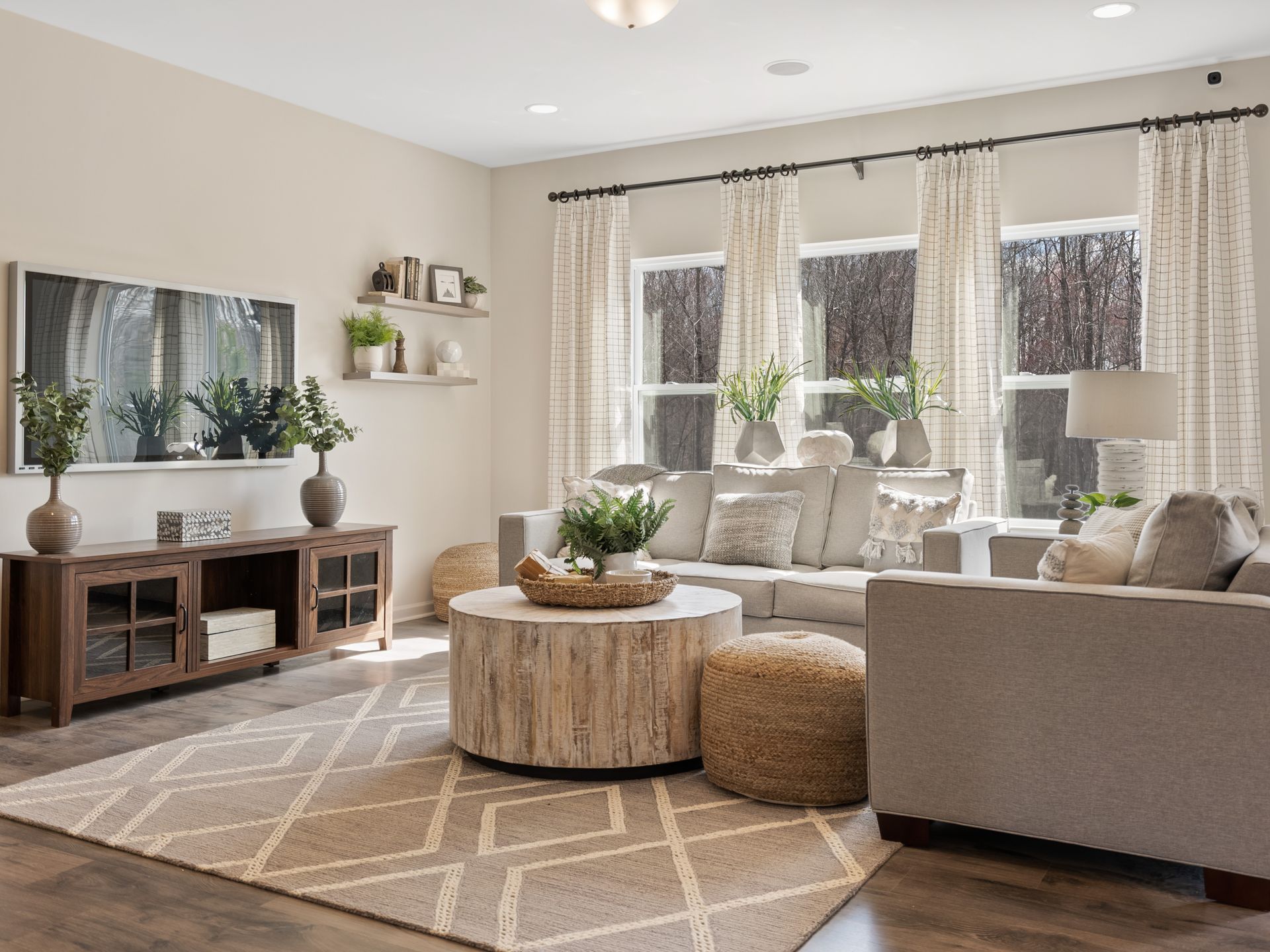 A living room with a couch , chair , coffee table and television.