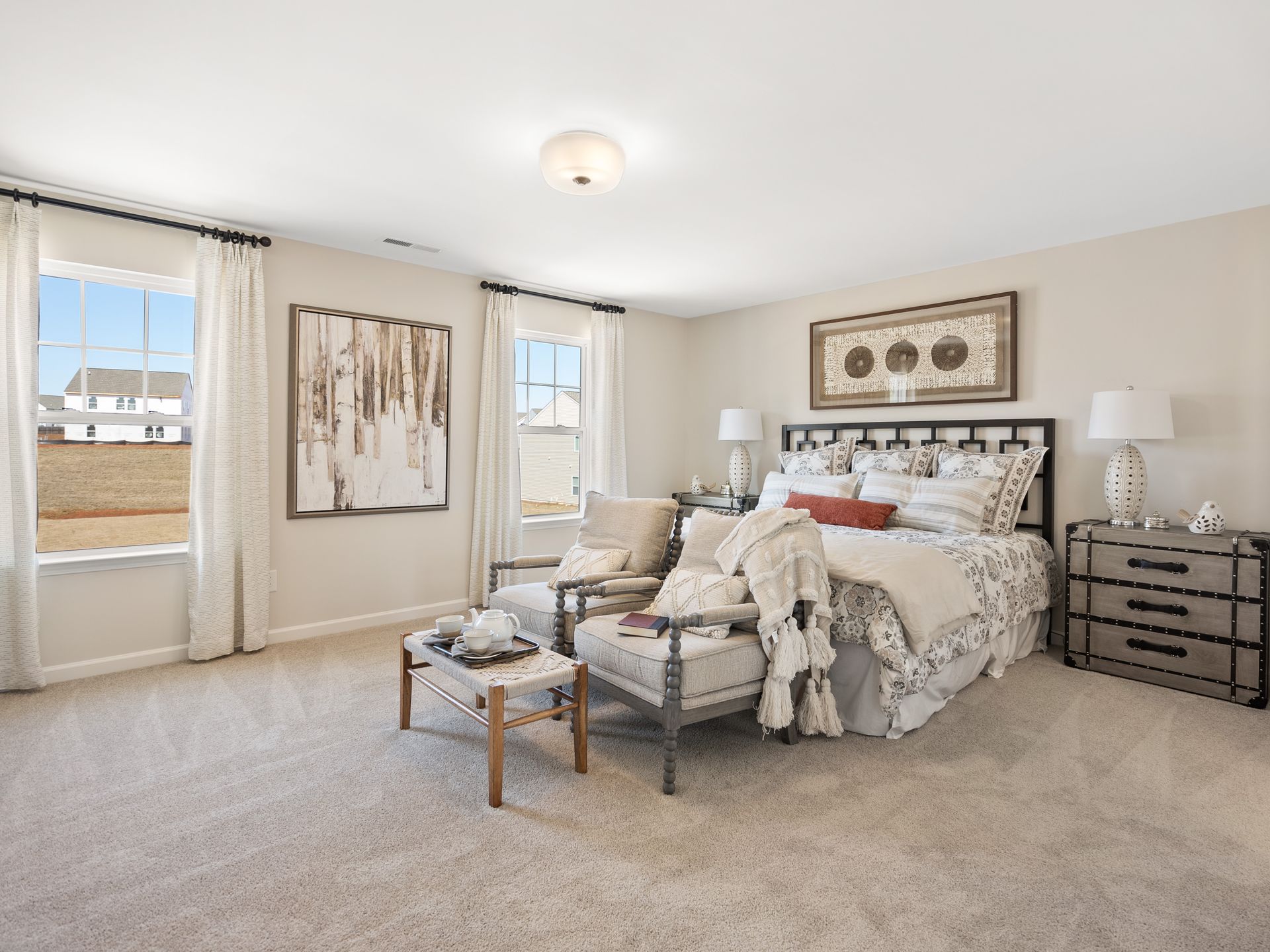 A bedroom with a bed , chair , nightstand , and window.