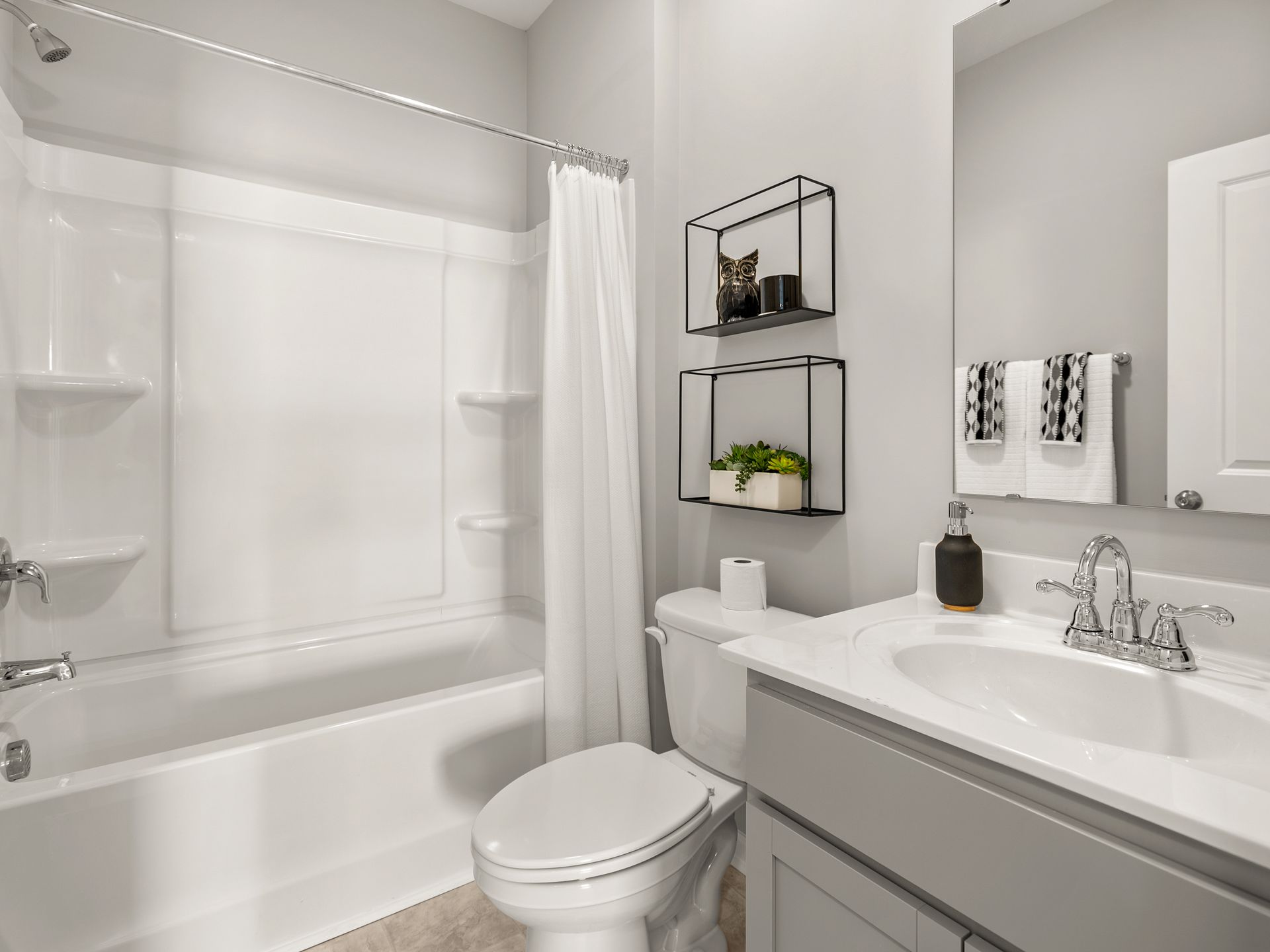 A bathroom with a toilet , sink , bathtub and mirror.