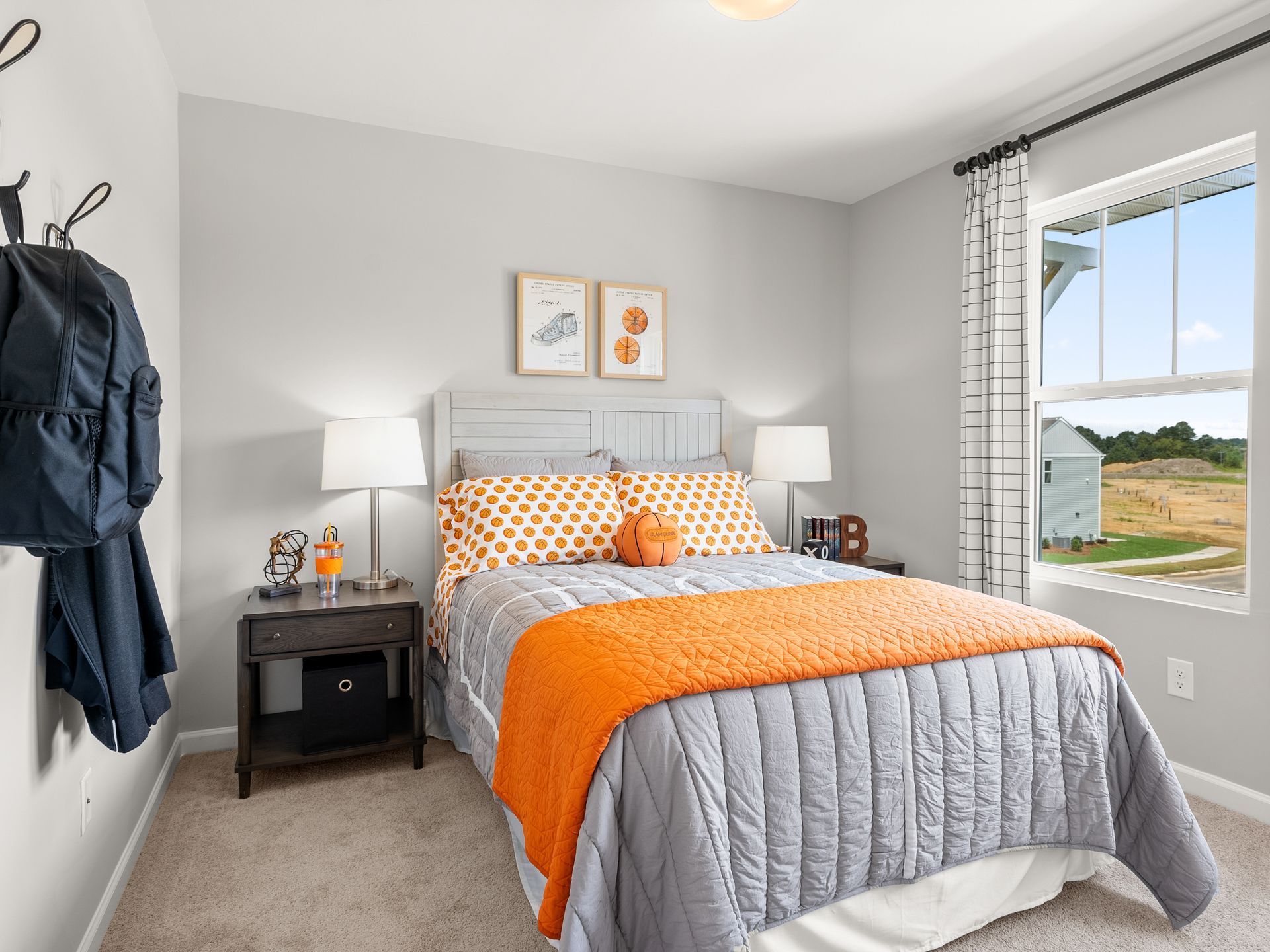 A bedroom with a bed , nightstand , lamps and a window.