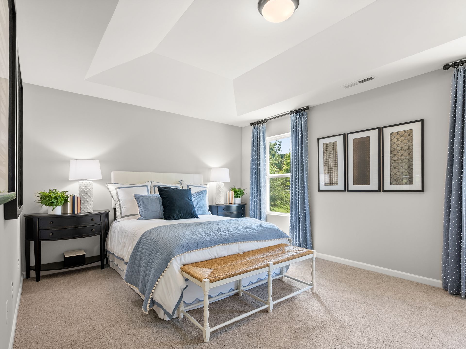 A bedroom with a large bed and a bench.