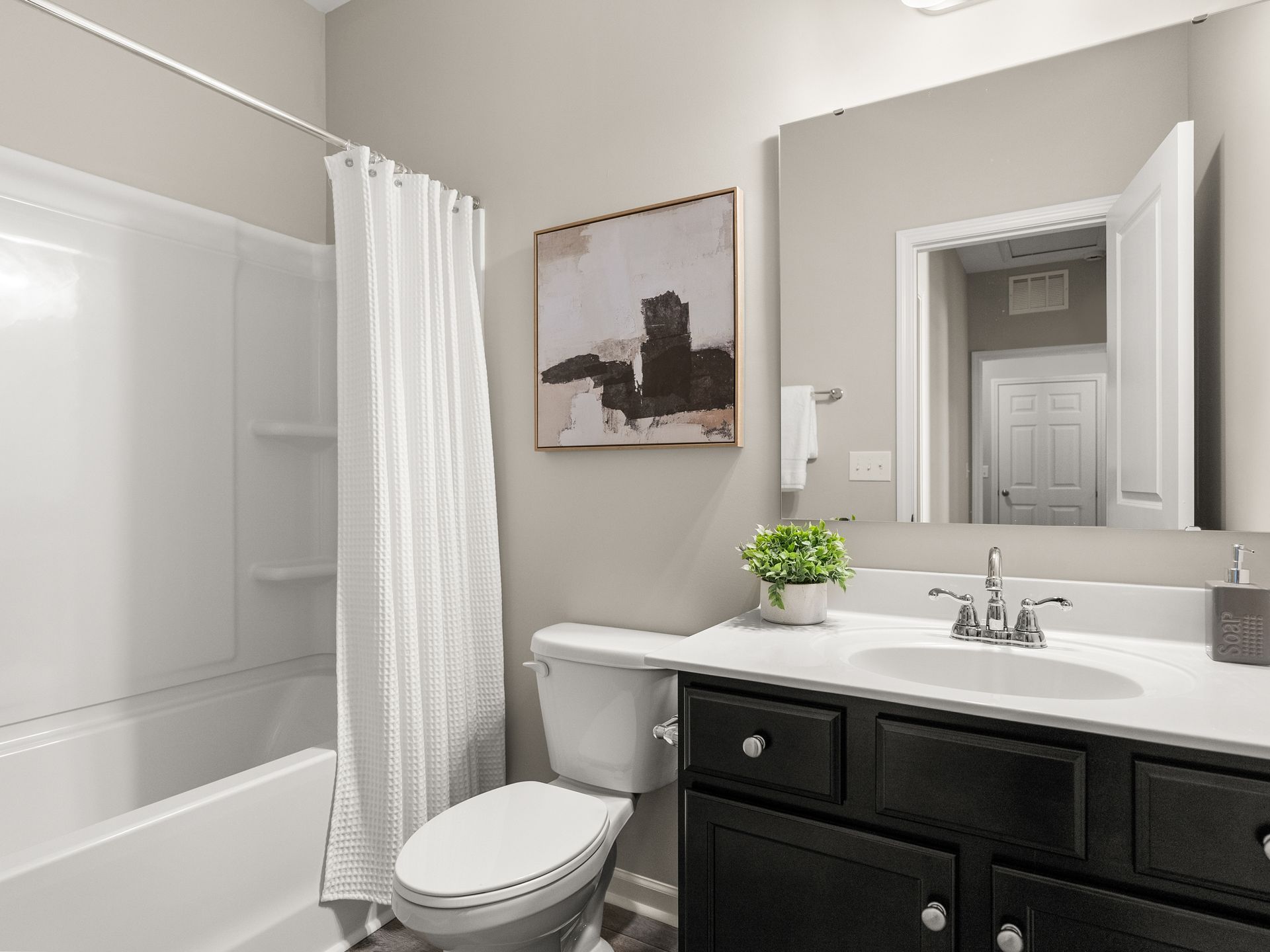 A bathroom with a toilet , sink , and bathtub.