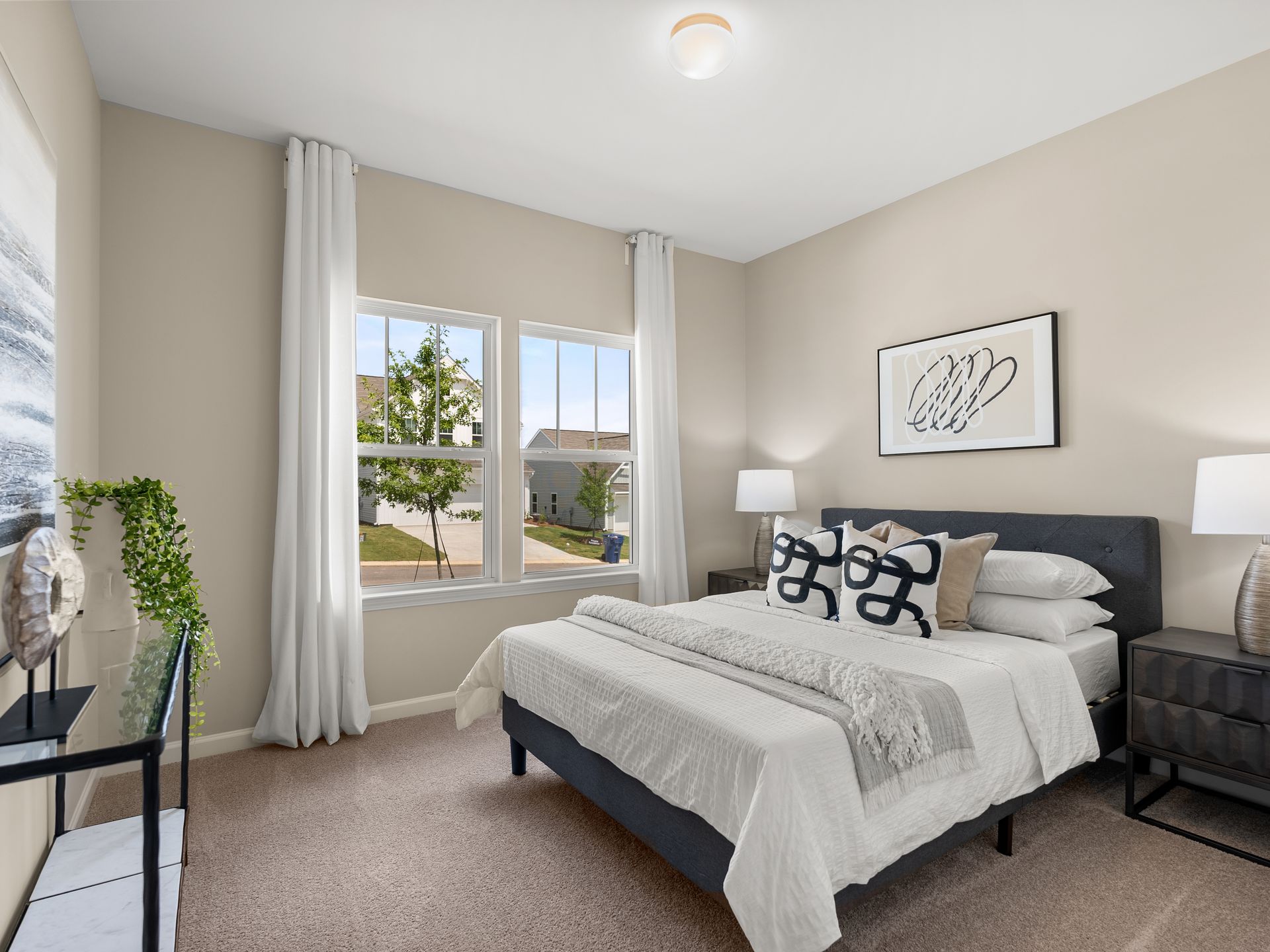 A bedroom with a bed , nightstand , and two windows.