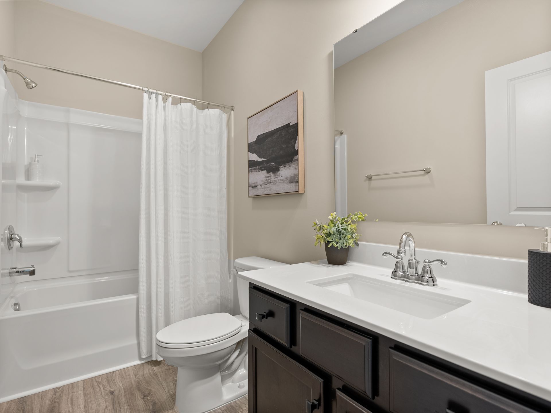 A bathroom with a toilet , sink , bathtub and shower.