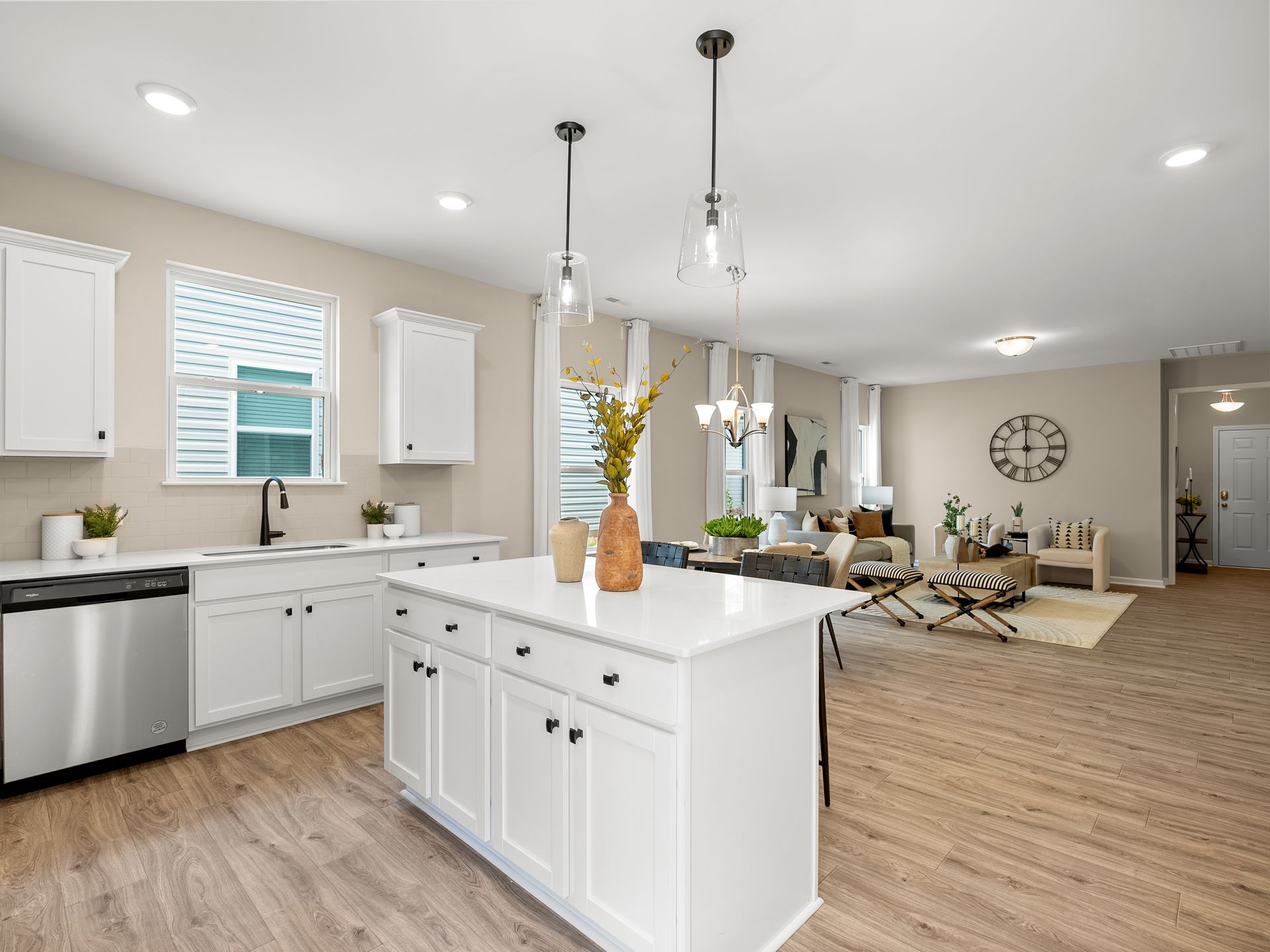 A kitchen with white cabinets and a large island in the middle of the room.