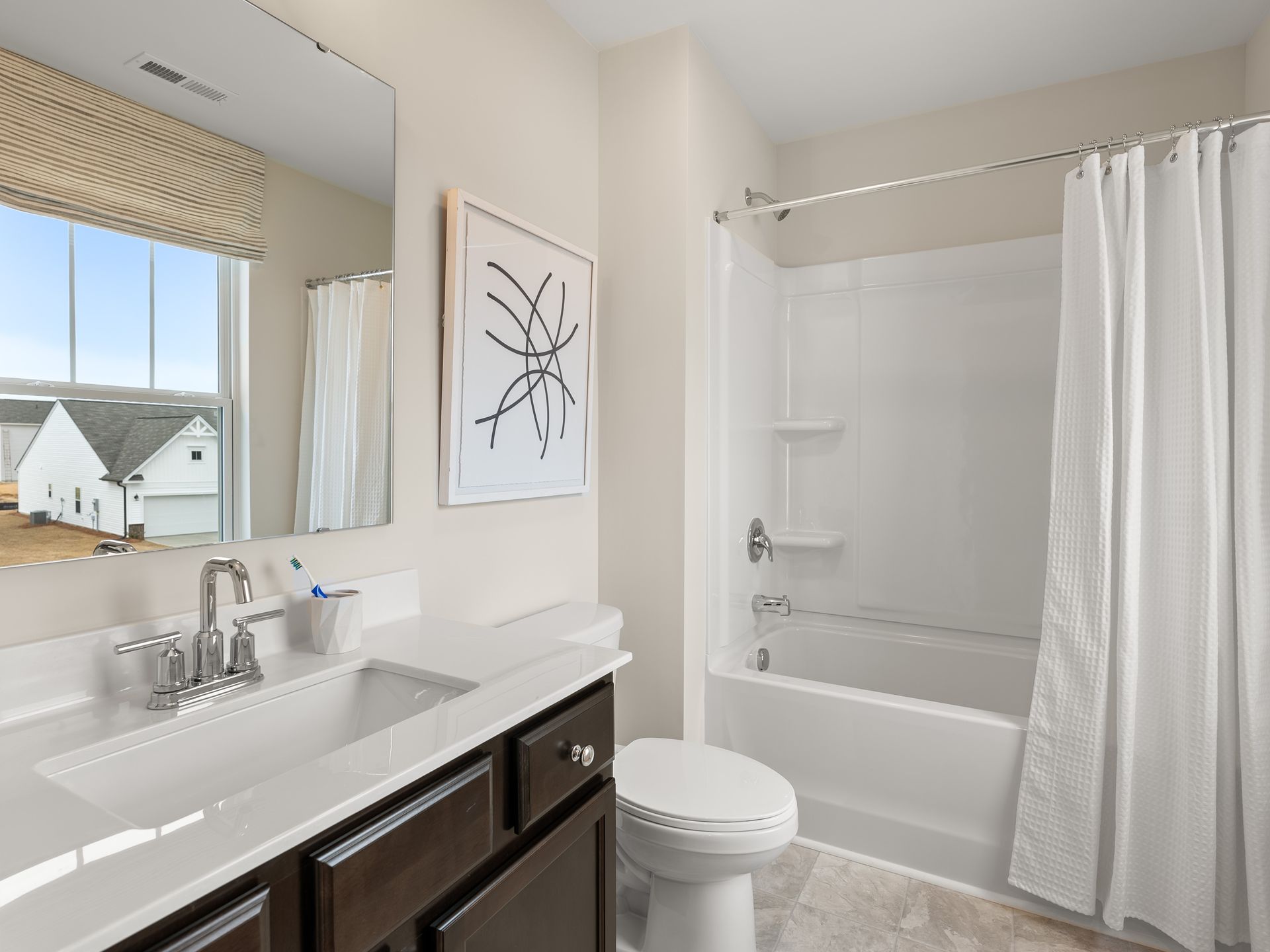 A bathroom with a sink , toilet , tub and mirror.