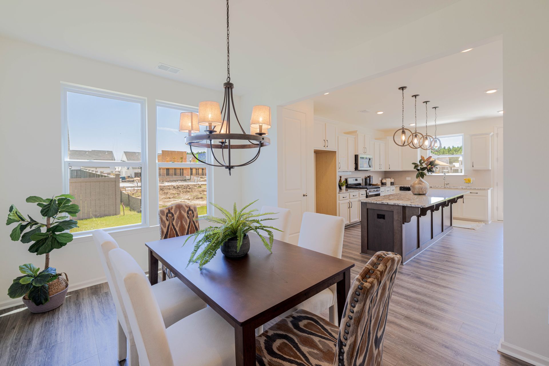 A dining room table and chairs in a house with a chandelier hanging from the ceiling.