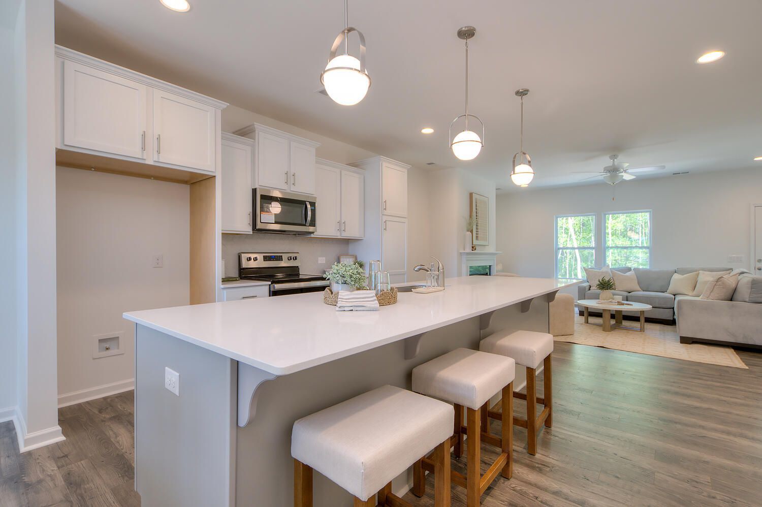 A kitchen with a large island and stools in a house.