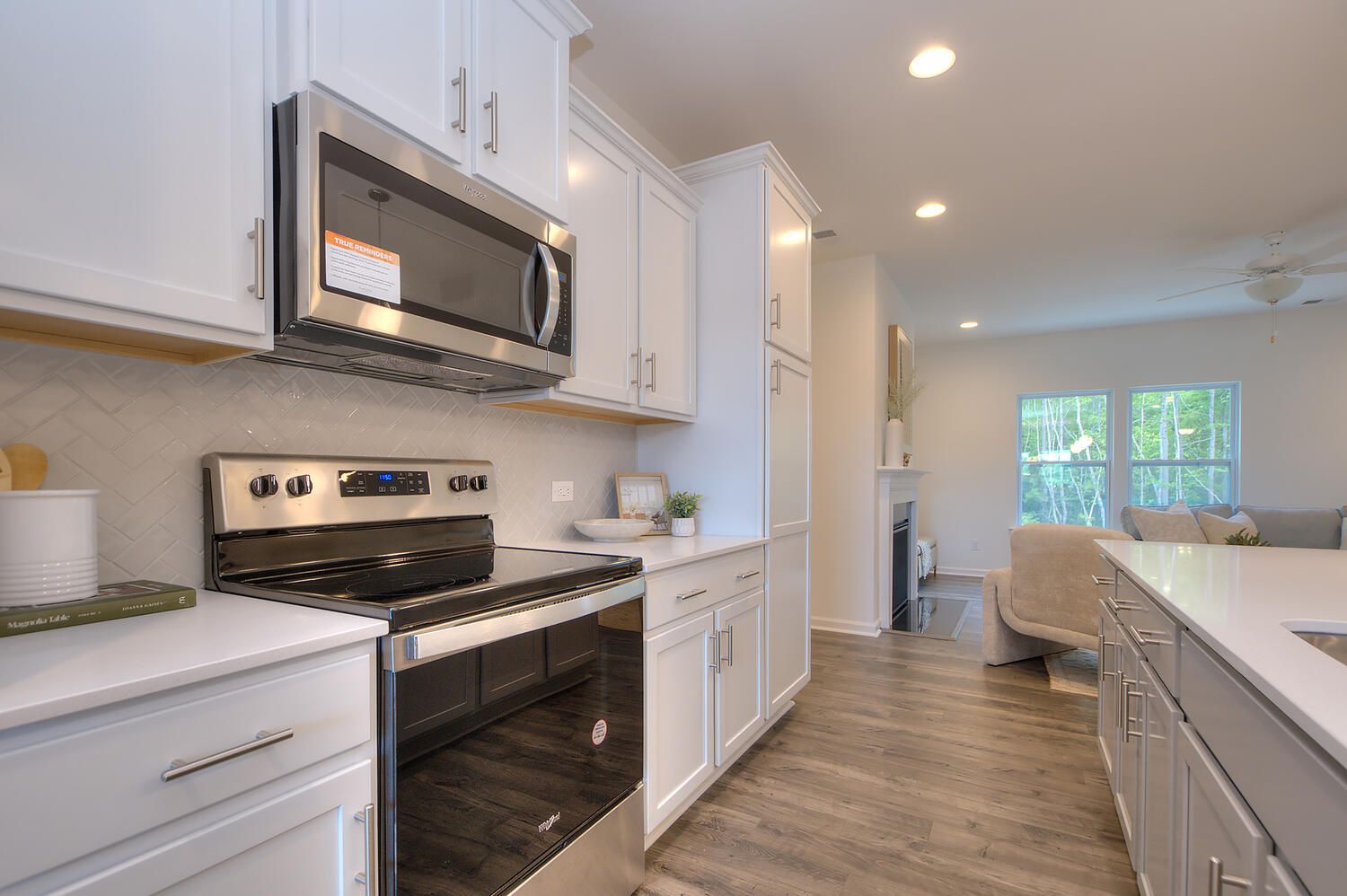 A kitchen with white cabinets , stainless steel appliances , and a microwave oven.