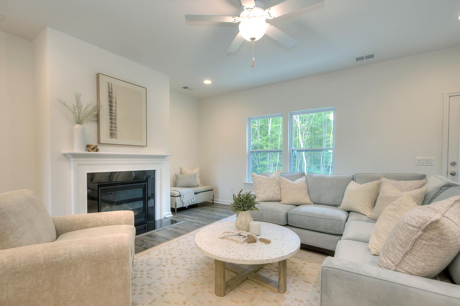 A living room with a couch , chair , coffee table and fireplace.