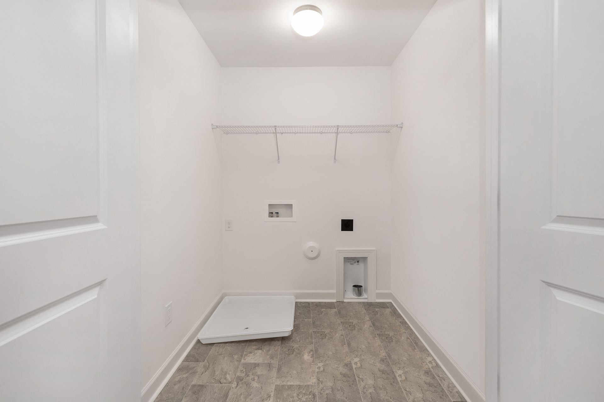 A laundry room in a house with a washer and dryer.