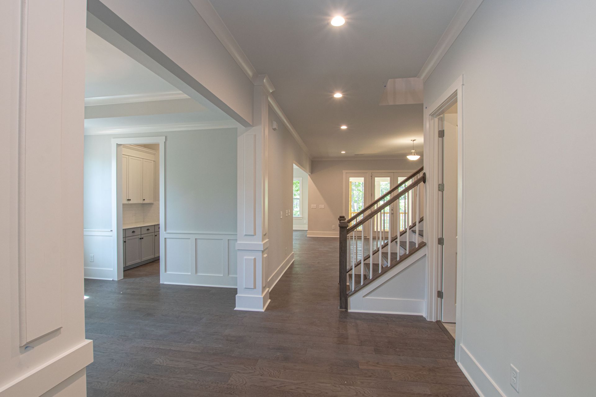 A hallway in a house with stairs leading up to the second floor.