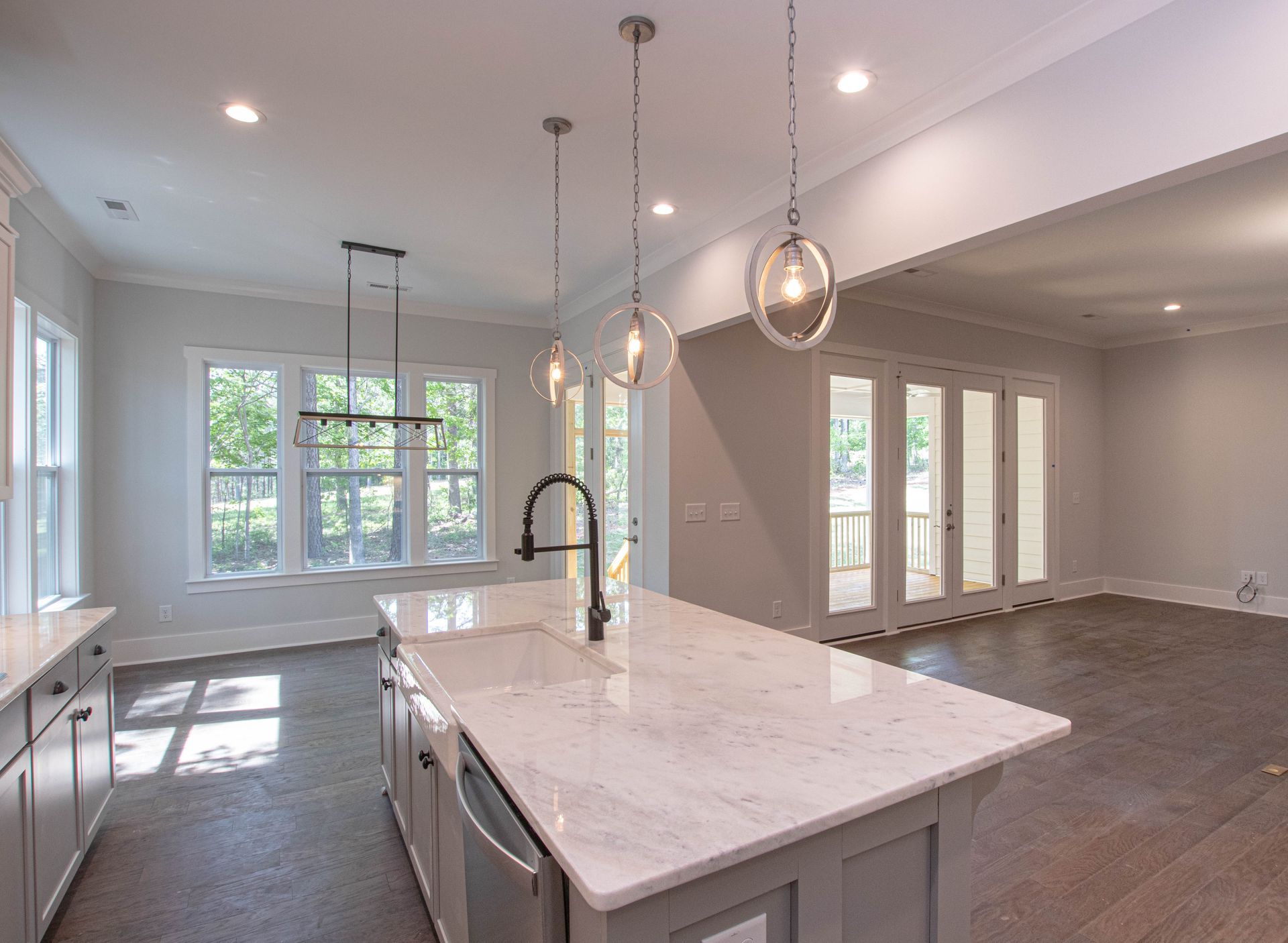 An empty kitchen with a large island and a sink.