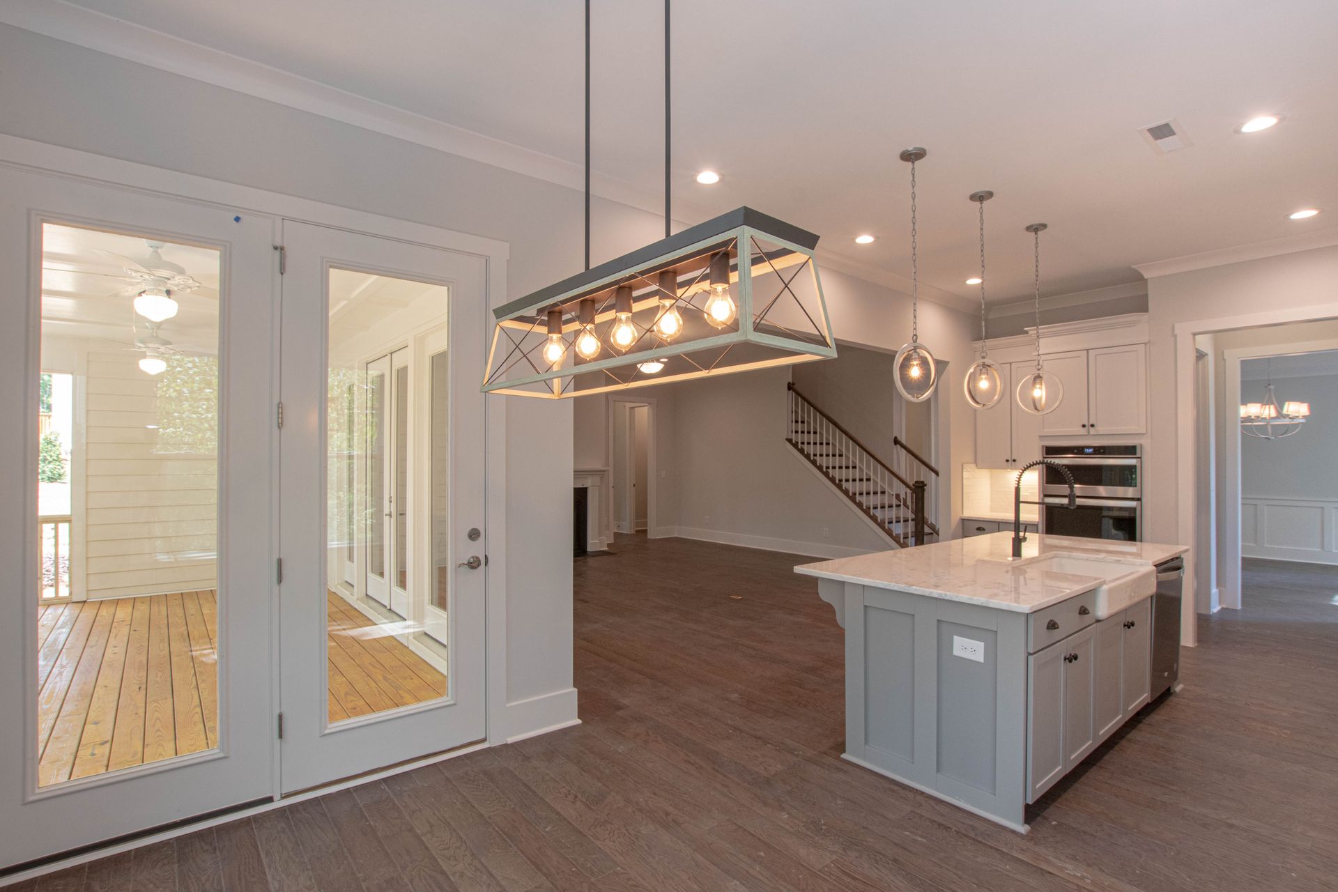 A kitchen with a large island and a chandelier hanging from the ceiling.