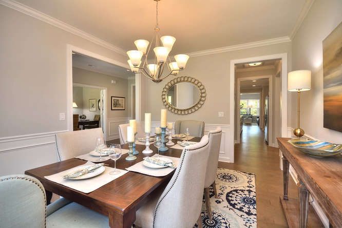 A dining room with a table and chairs and a chandelier.