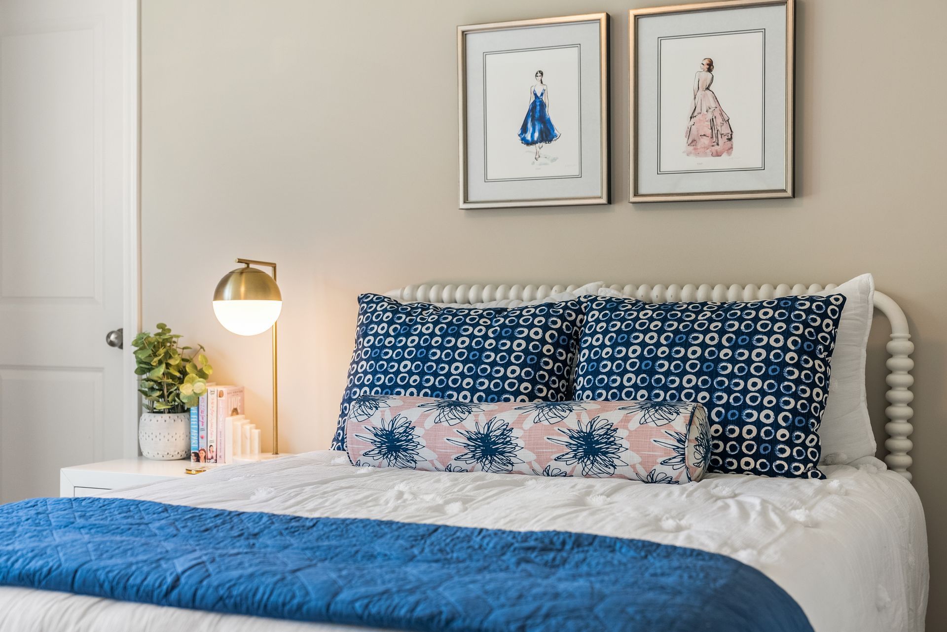 There are two paintings on the wall above the bed.