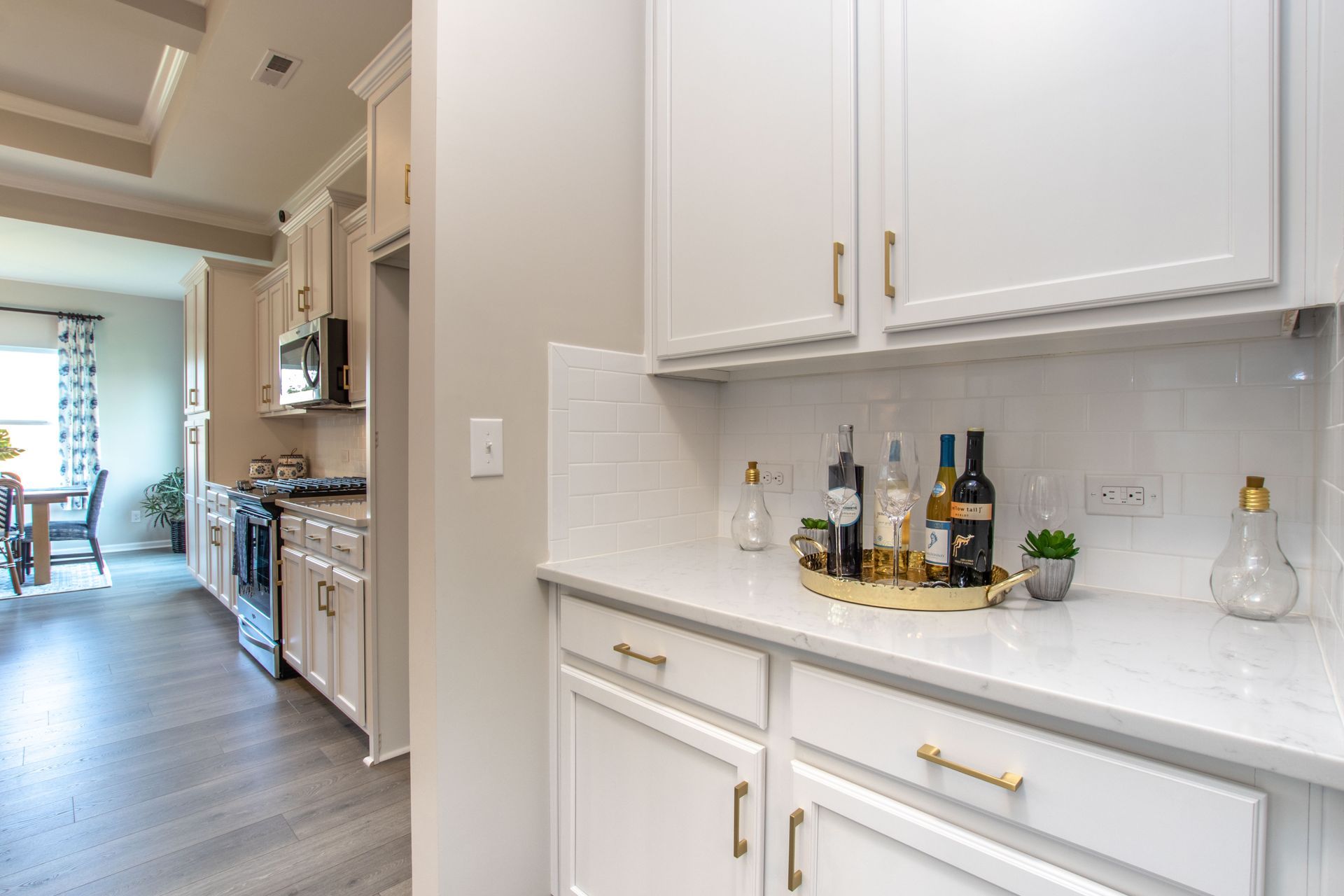 A kitchen with white cabinets and a tray of wine on the counter.