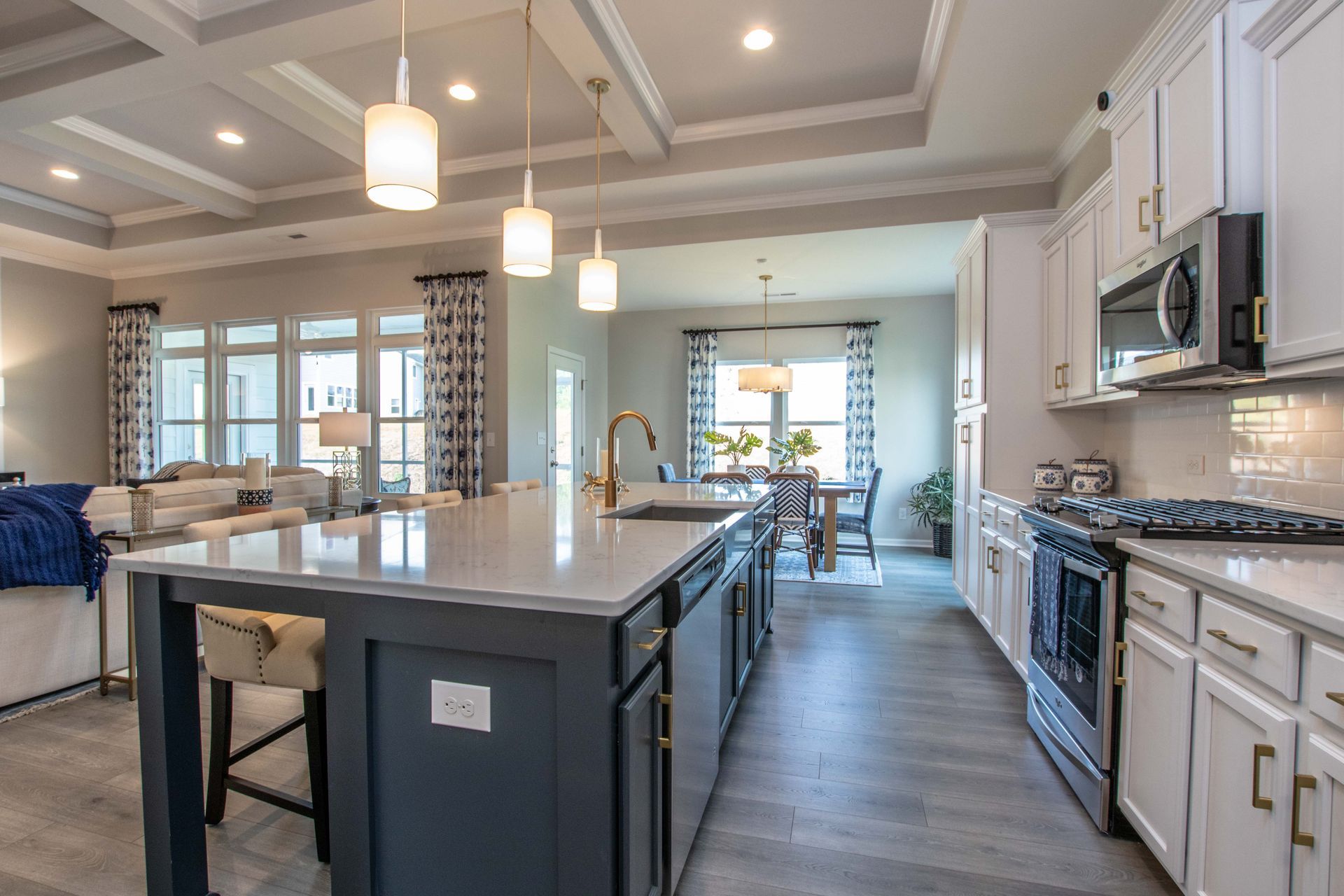 A kitchen in a model home with a large island in the middle.