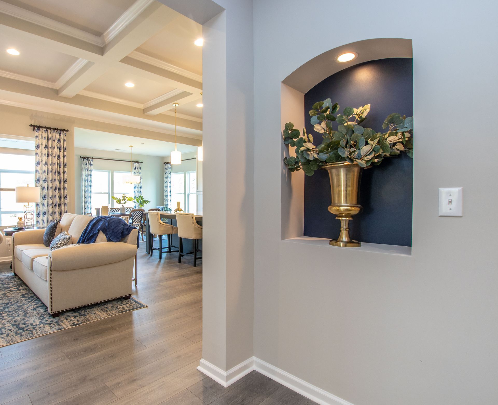 A living room with a couch and a vase on the wall.
