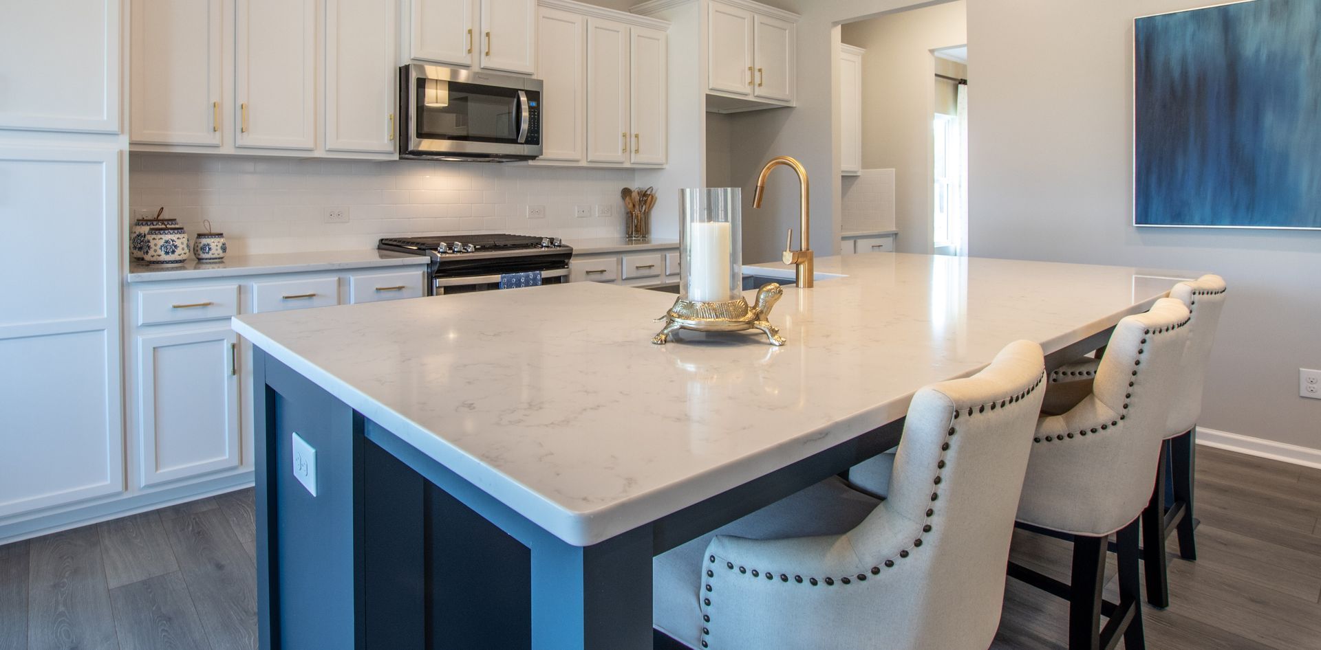 A kitchen with white cabinets and a large island in the middle.
