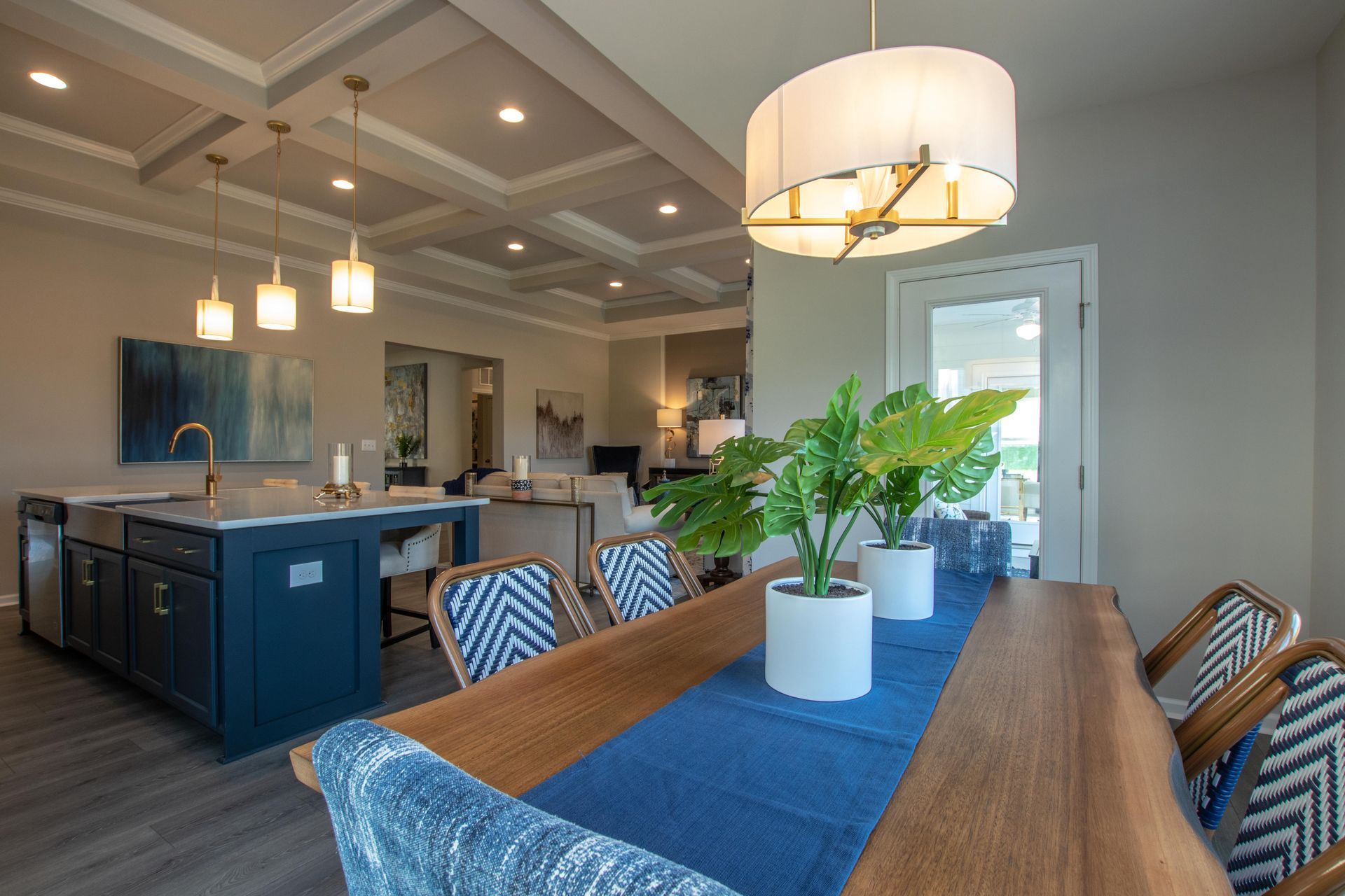A dining room table with a blue table cloth and chairs in a house.