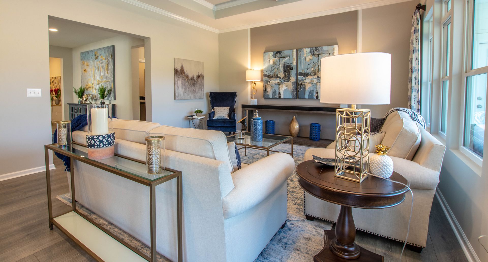 A living room with a couch , chair , table and lamps.