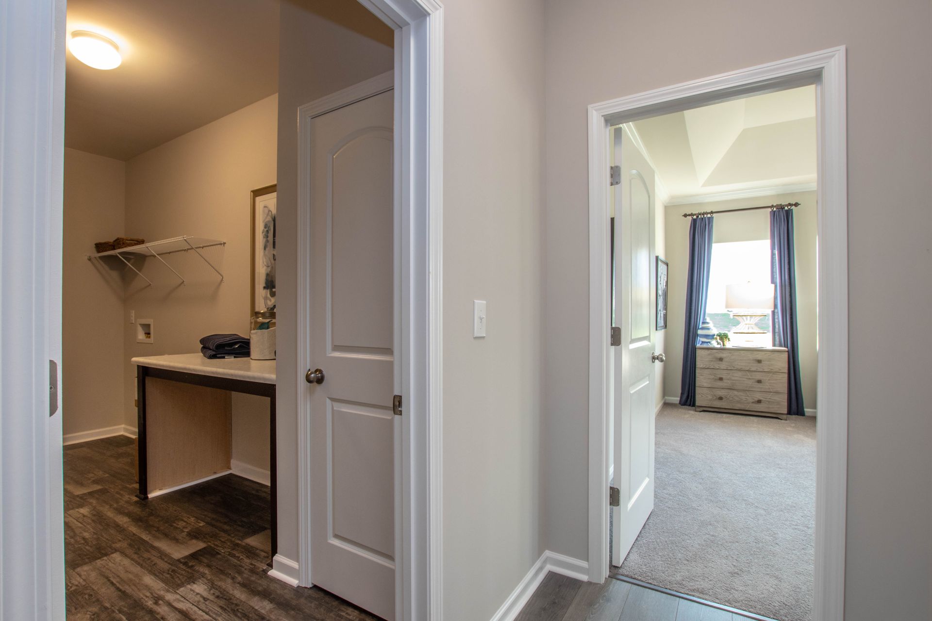 A hallway in a house leading to a bedroom and a closet.