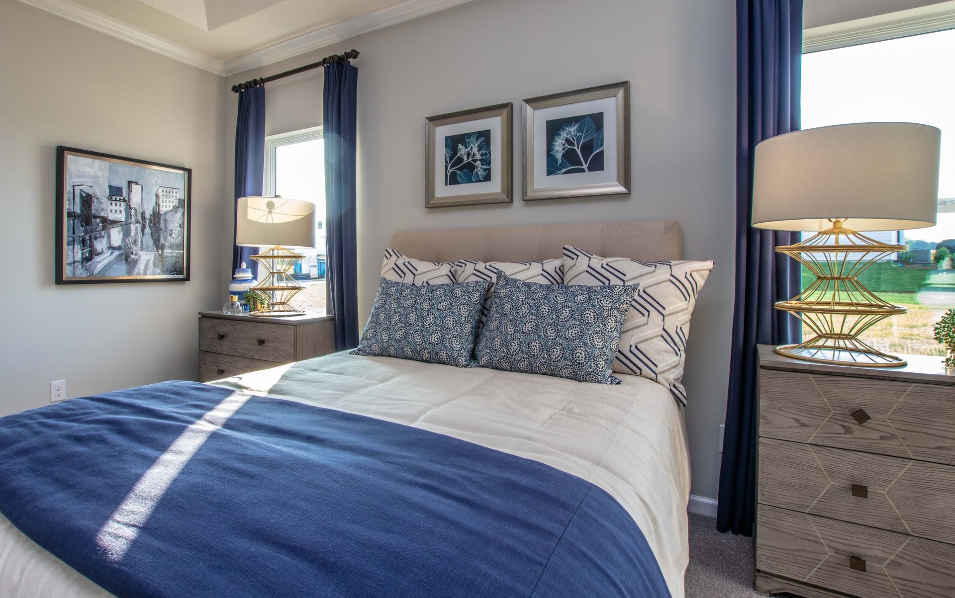 A bedroom with a bed , nightstand , dresser and two lamps.